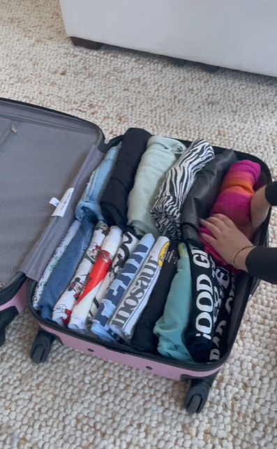 TikToker EF Ultimate Break rolling her clothes and putting them in a suitcase, as seen in a video March 10, 2023 | Source: TikTok/efultimatebreak