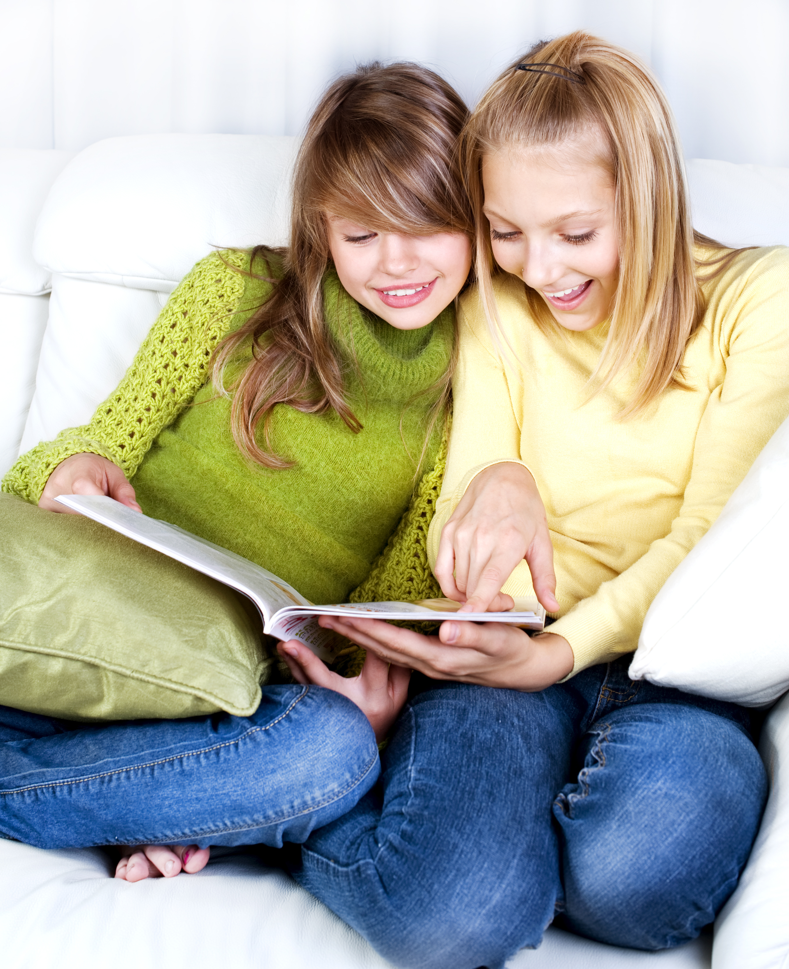 Two girls smiling as they look at a diary | Source: Shutterstock