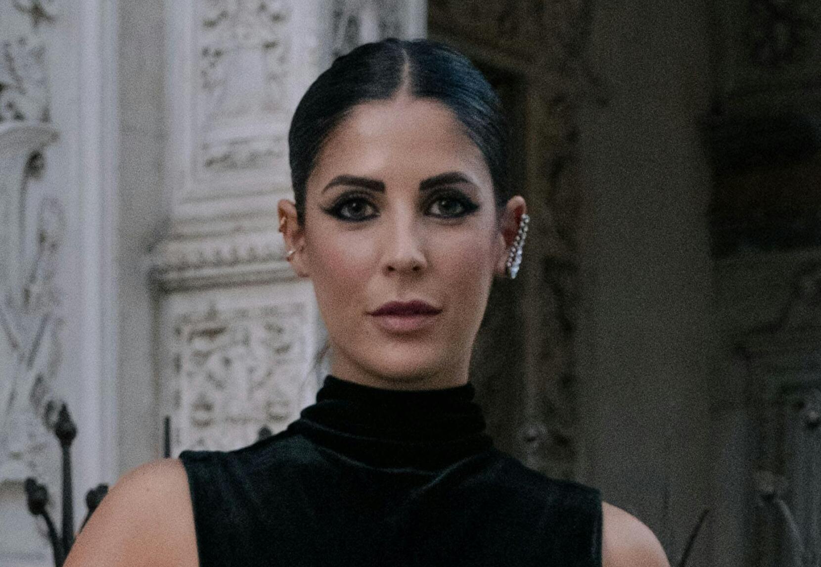 A woman in a black velvet dress with a serious expression | Source: Pexels