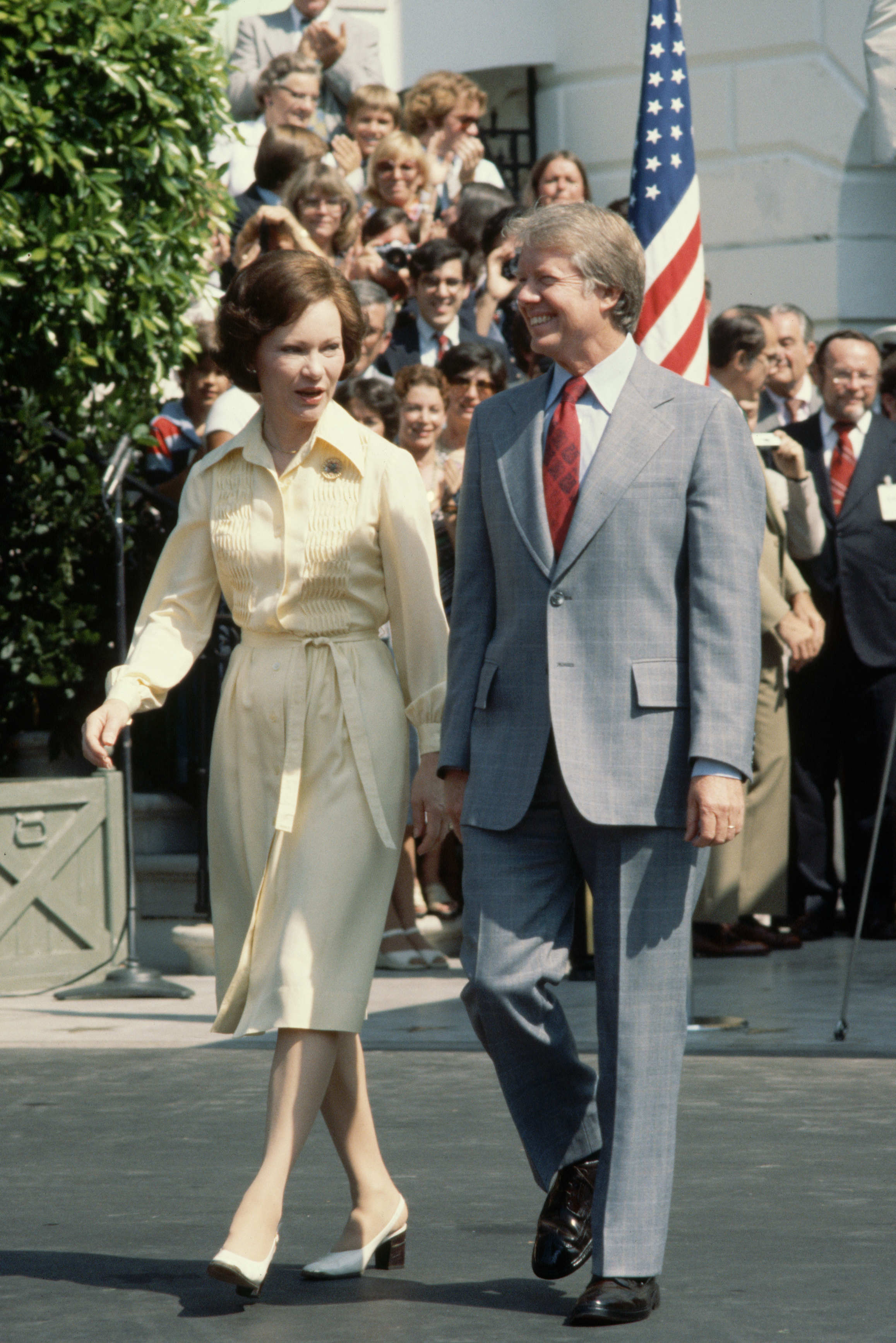 Rosalynn and Jimmy Carter take a walk down, observed by a crowd of spectators, on the South Lawn drive at the White House on July 19, 1977. | Source: Getty Images