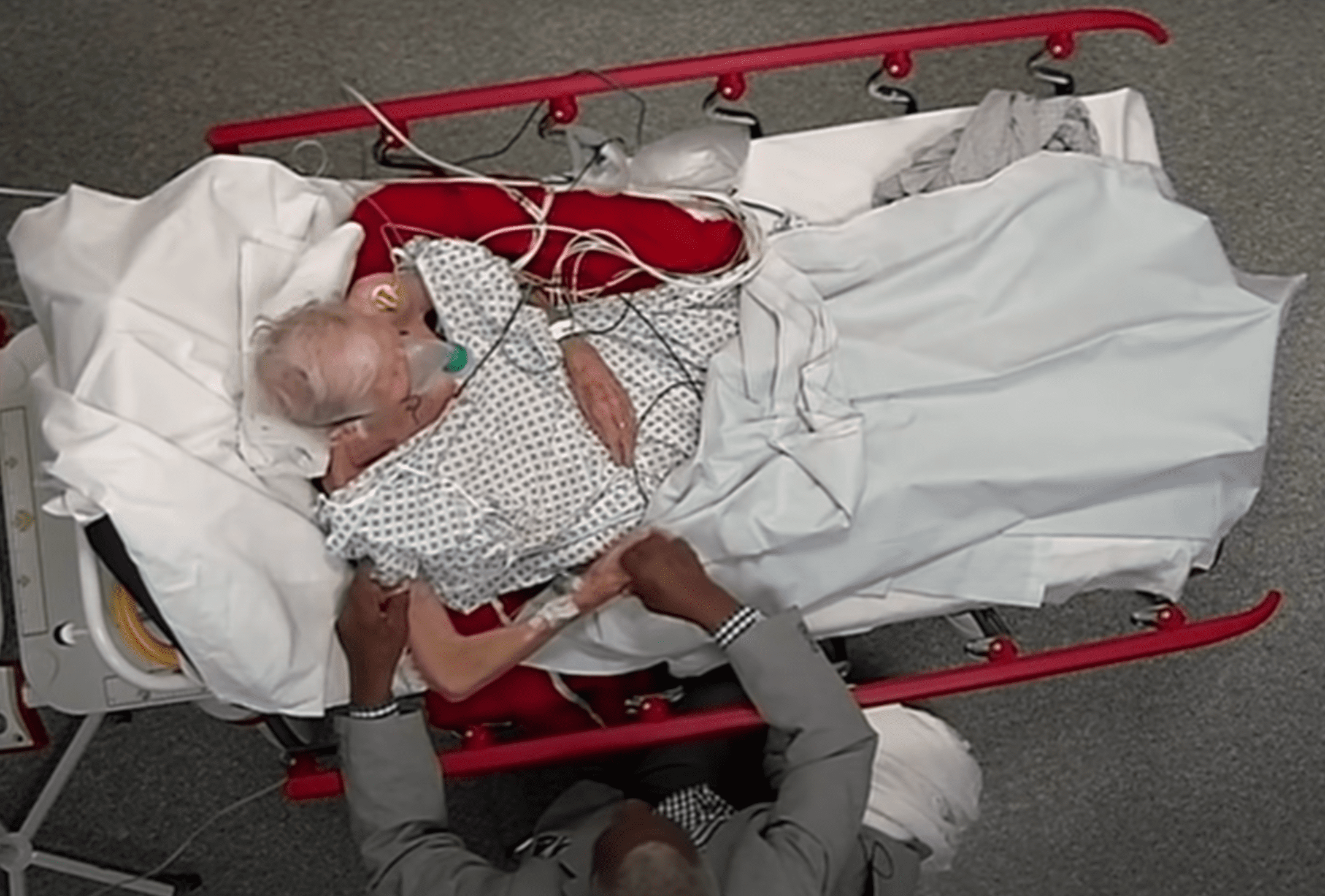 Doreen Augustus recostada en una cama de hospital y su esposo a su lado. | Foto: Youtube.com/Channel 4