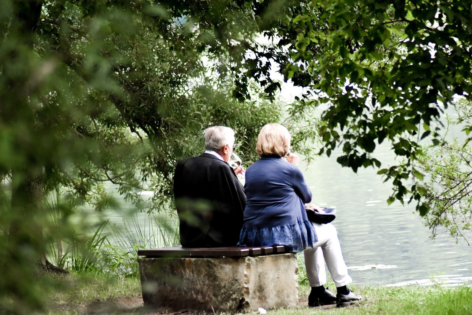 An old couple sitting by the sea. | Photo: Unsplash