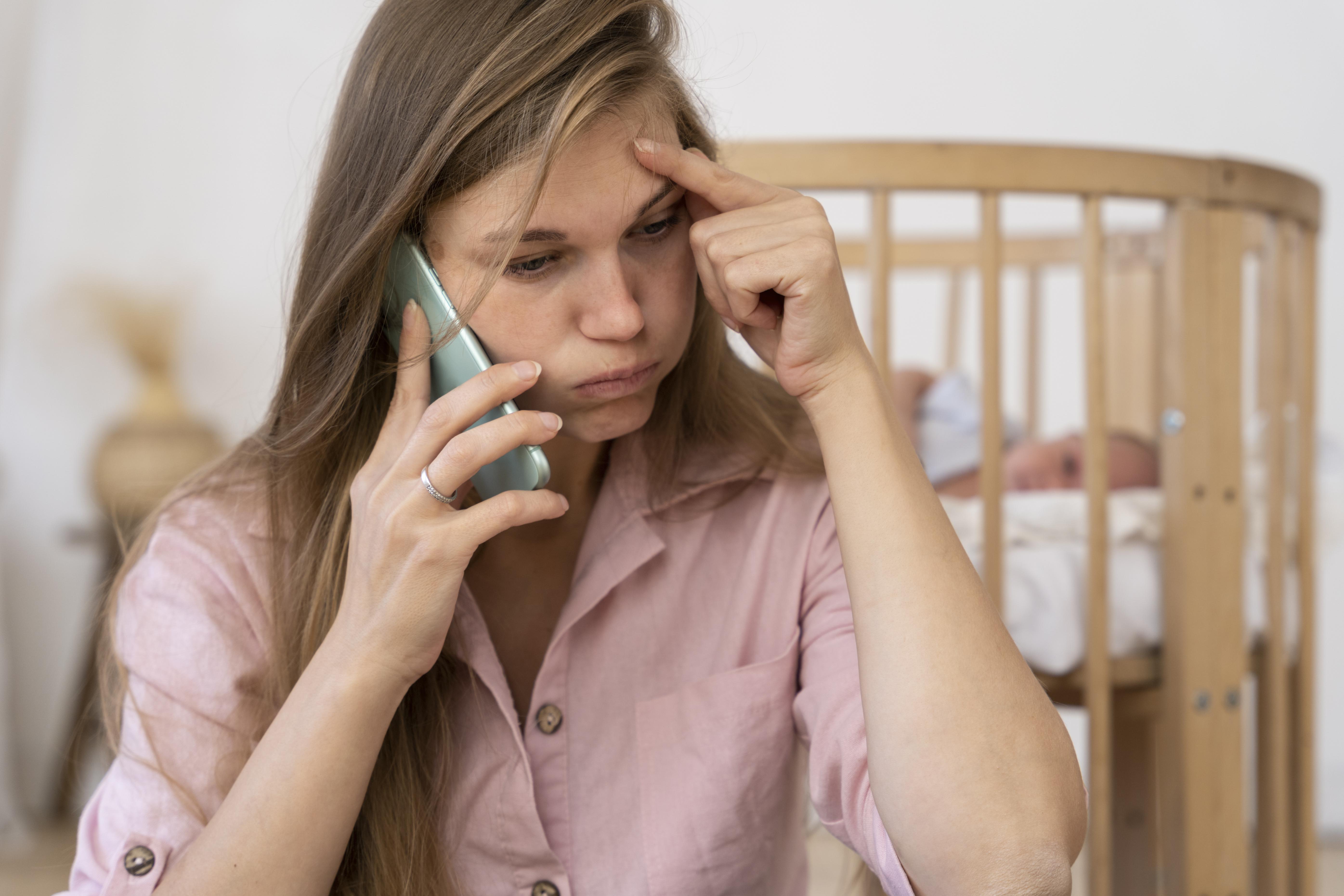 Eine gestresste Mutter am Telefon | Quelle: Freepik.com