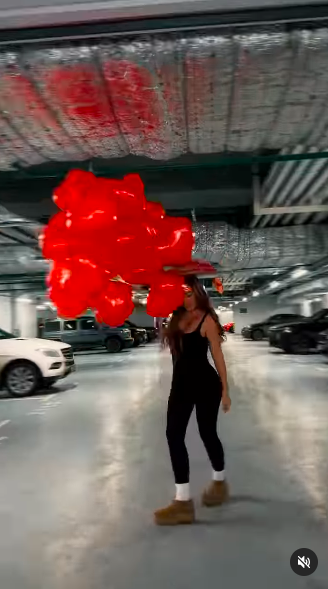 Anna Sedokova twirling around a parking lot with red heart-shaped balloons in her second birthday video, posted on December 16, 2024 | Source: Instagram/annasedokova