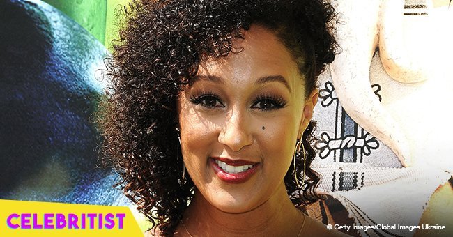 Tamera Mowry flaunts curves in plunging floral dress and high heels