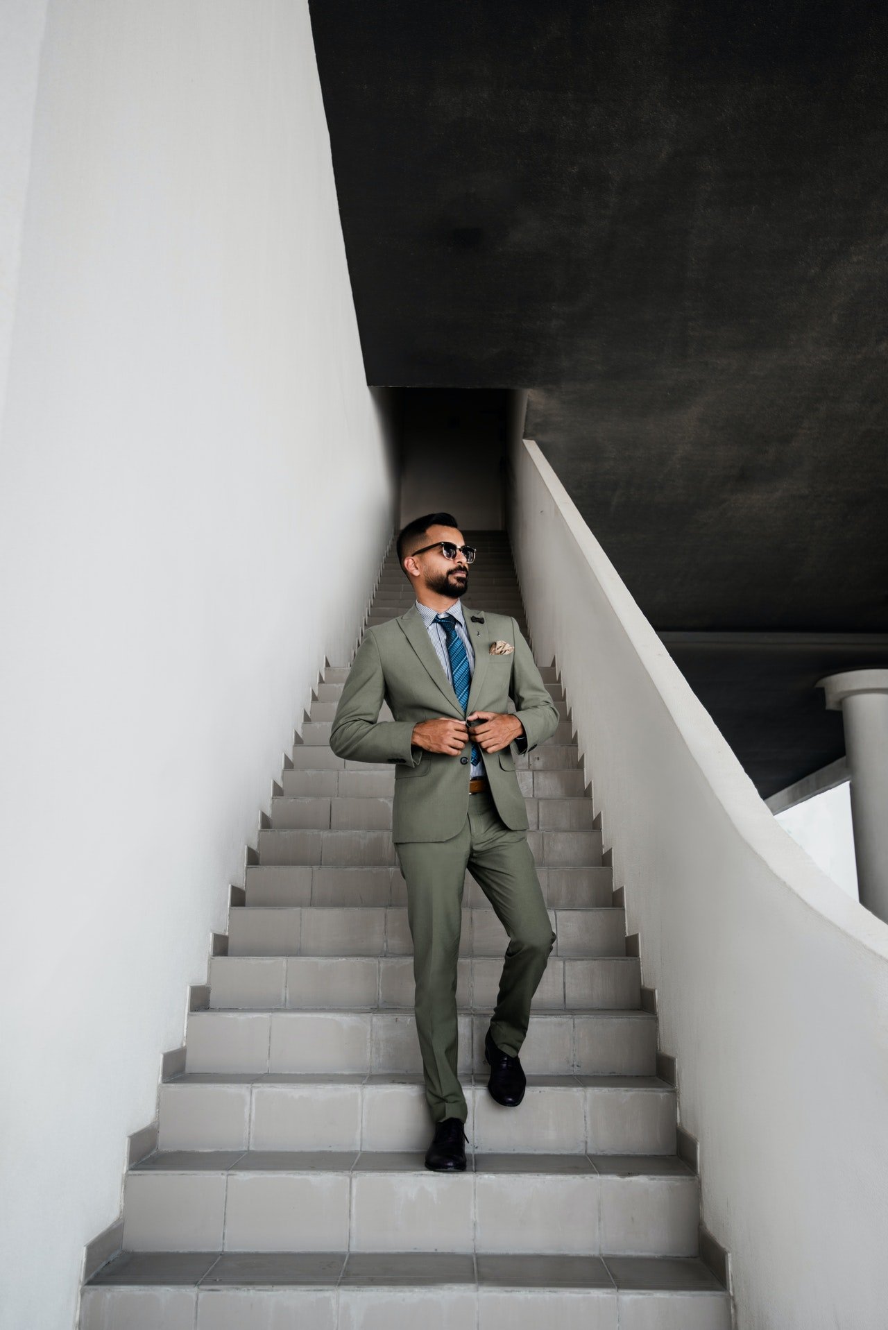 A man in grey suit standing on a stair | Photo: Pexels