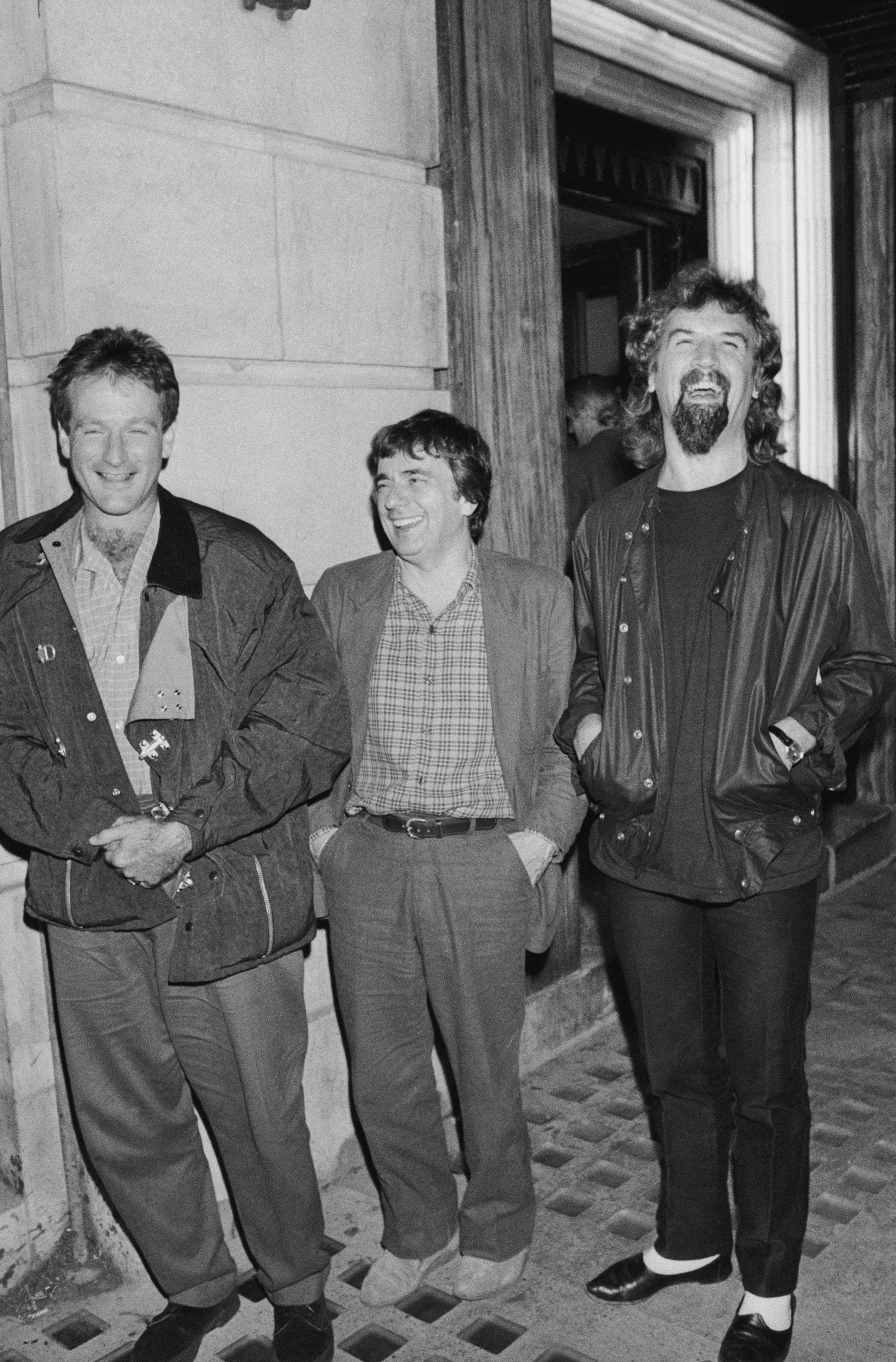 (L-R) Robin Williams, Dudley Moore, and Billy Connolly photographed outside Langans restaurant on January 1, 1985, in London, England. | Source: Getty Images