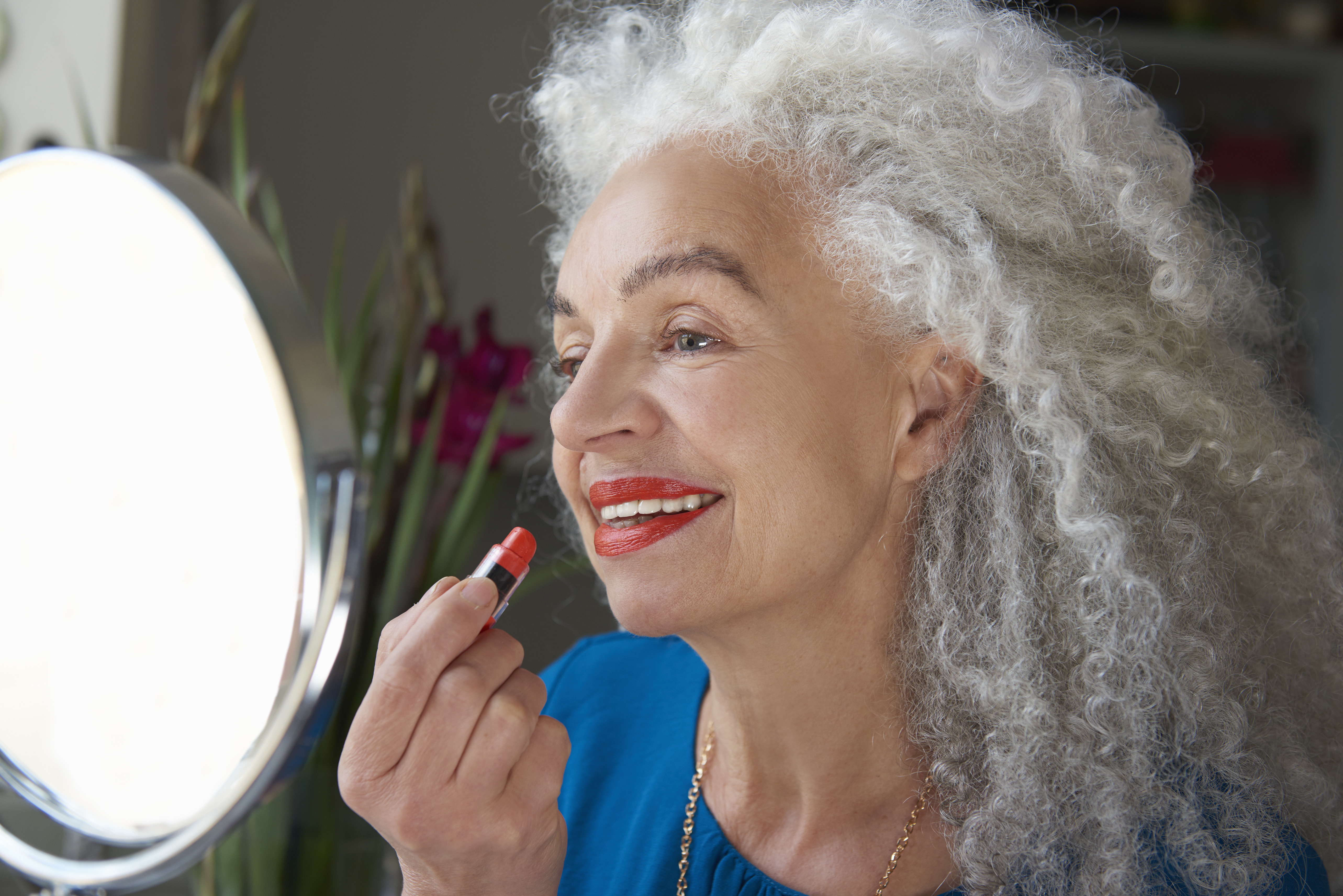 Woman applying red lipstick | Source: Getty Images