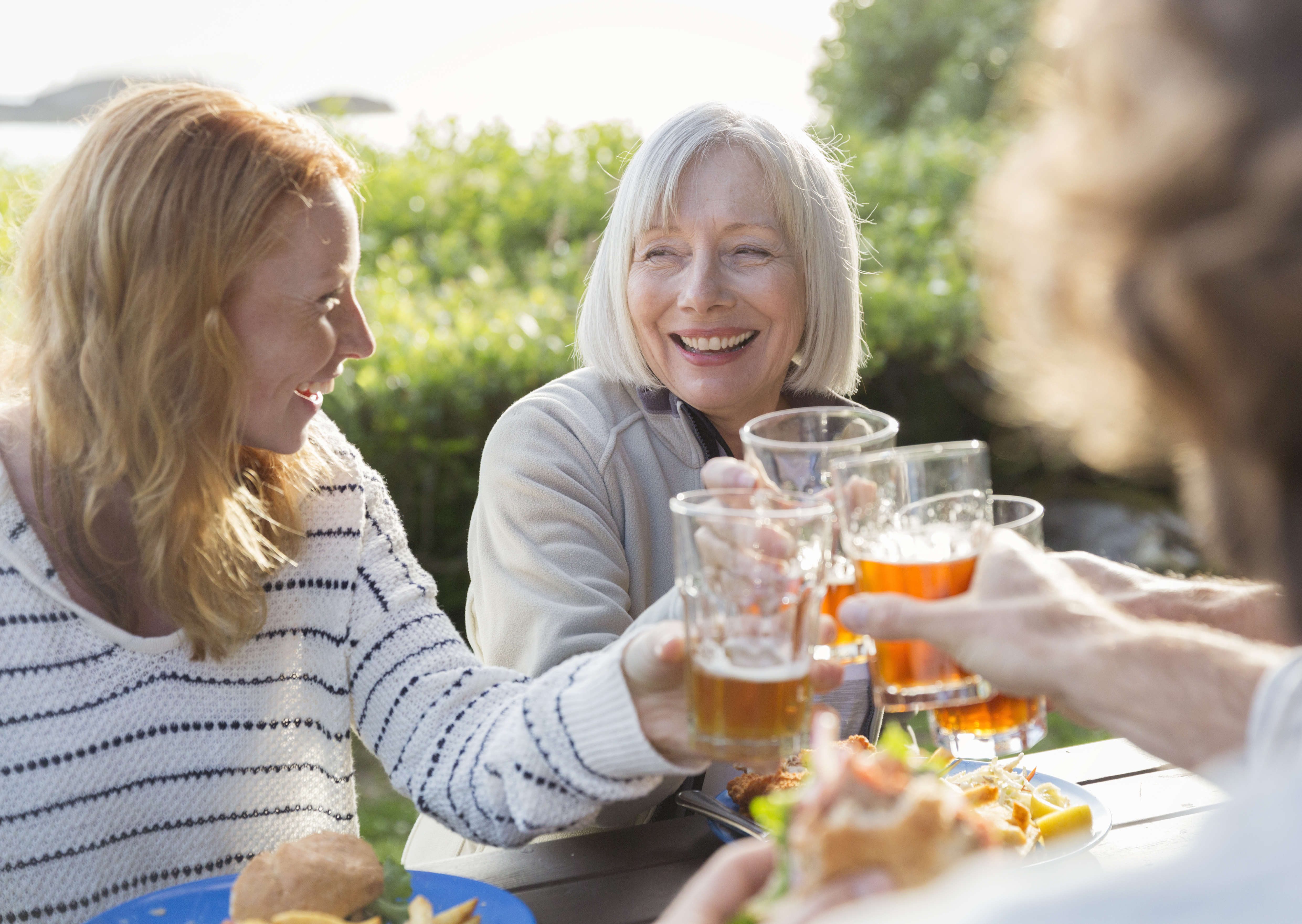 Two women raise their drinks in a toast | Source: Getty Images