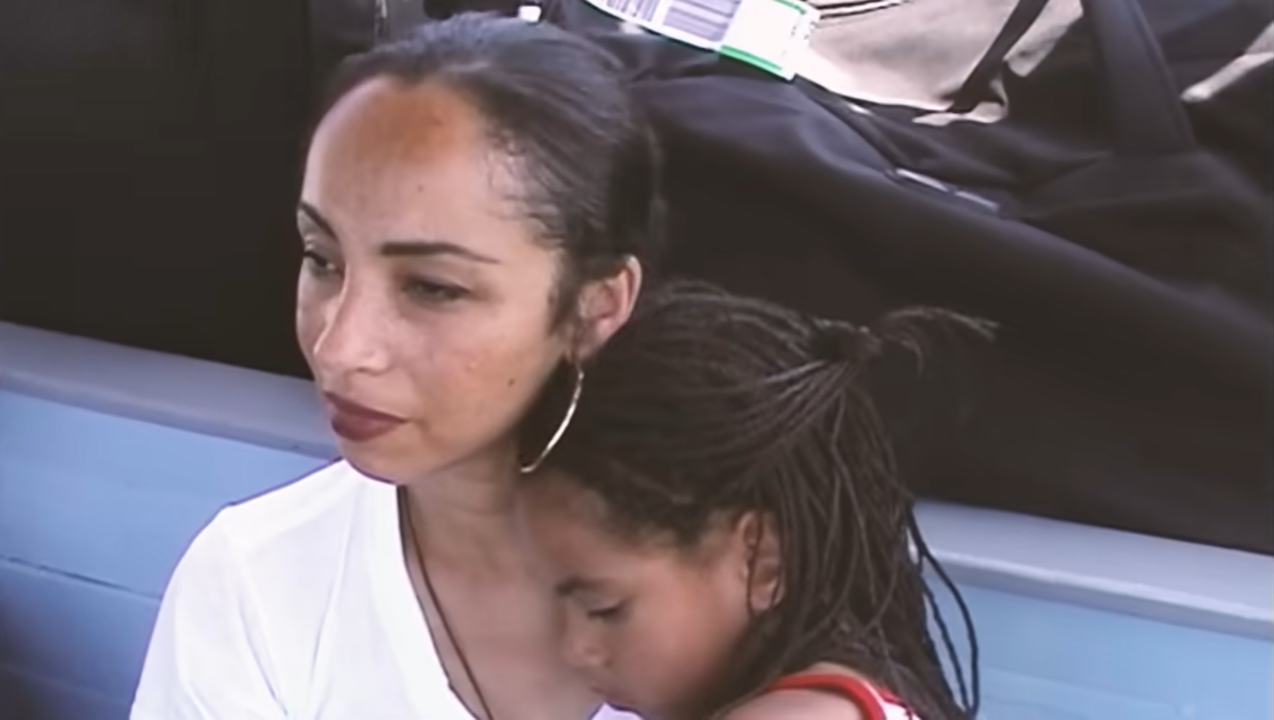 Sade cuddles her child, as seen in a video dated November 23, 2024 | Source: YouTube/@SadeSME