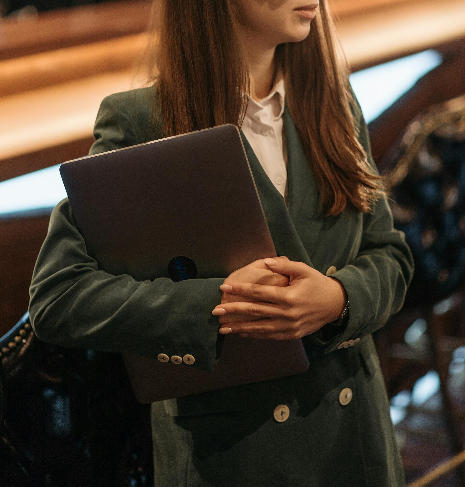 Close-up of a woman holding a laptop | Source: Pexels