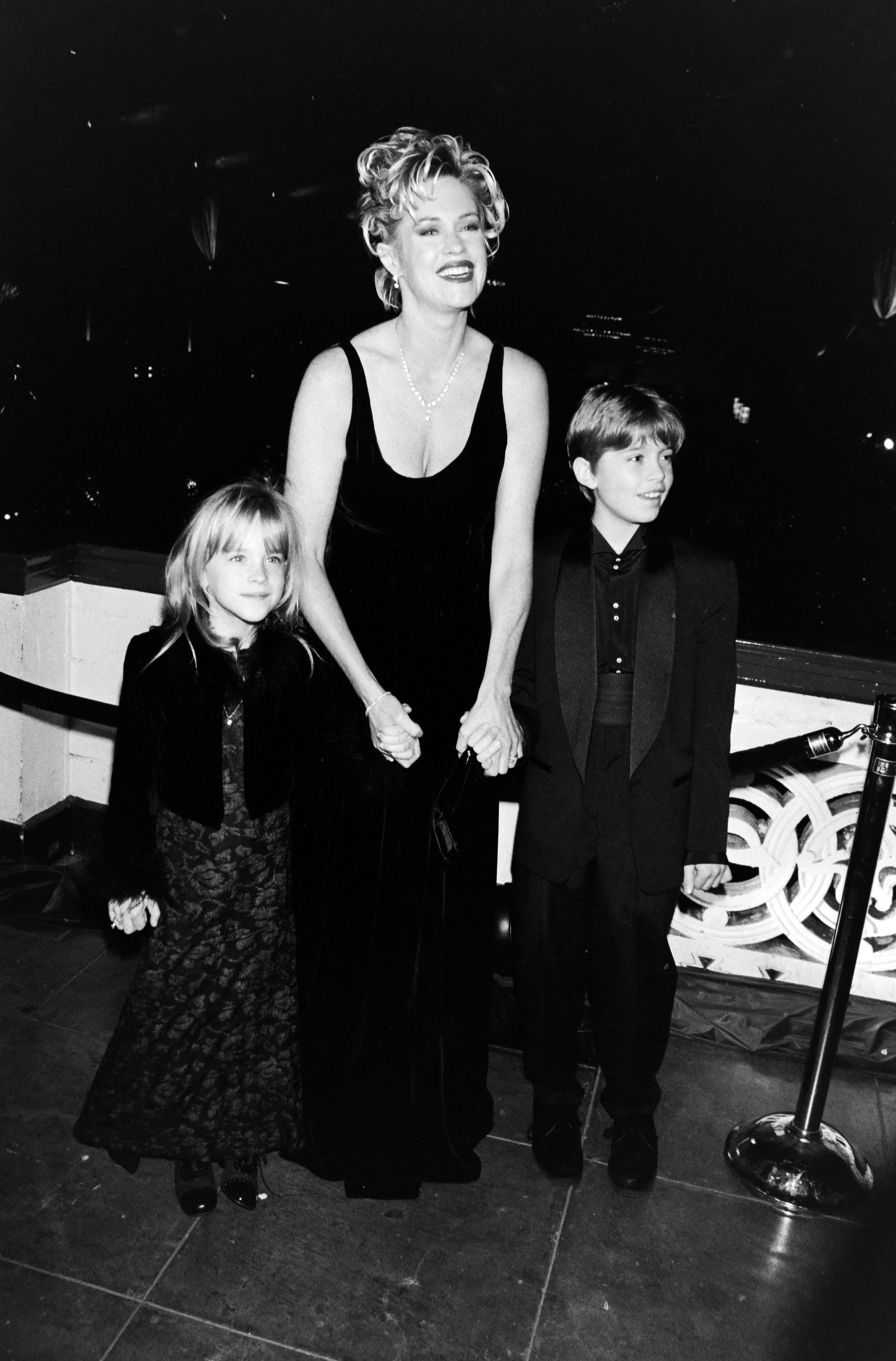 Melanie Griffith with her daughter Dakota Johnson and her son Alexander Bauer at the premiere of "Evita" on December 14, 1996, in Los Angeles, California. | Source: Getty Images