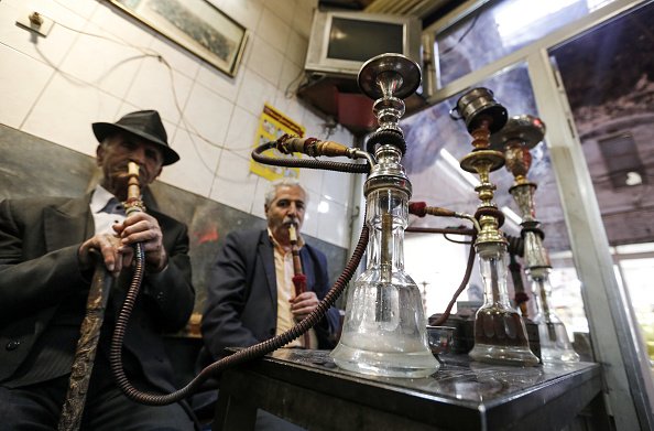 Des hommes entrain de consommer la chicha.| Photo : Getty Images
