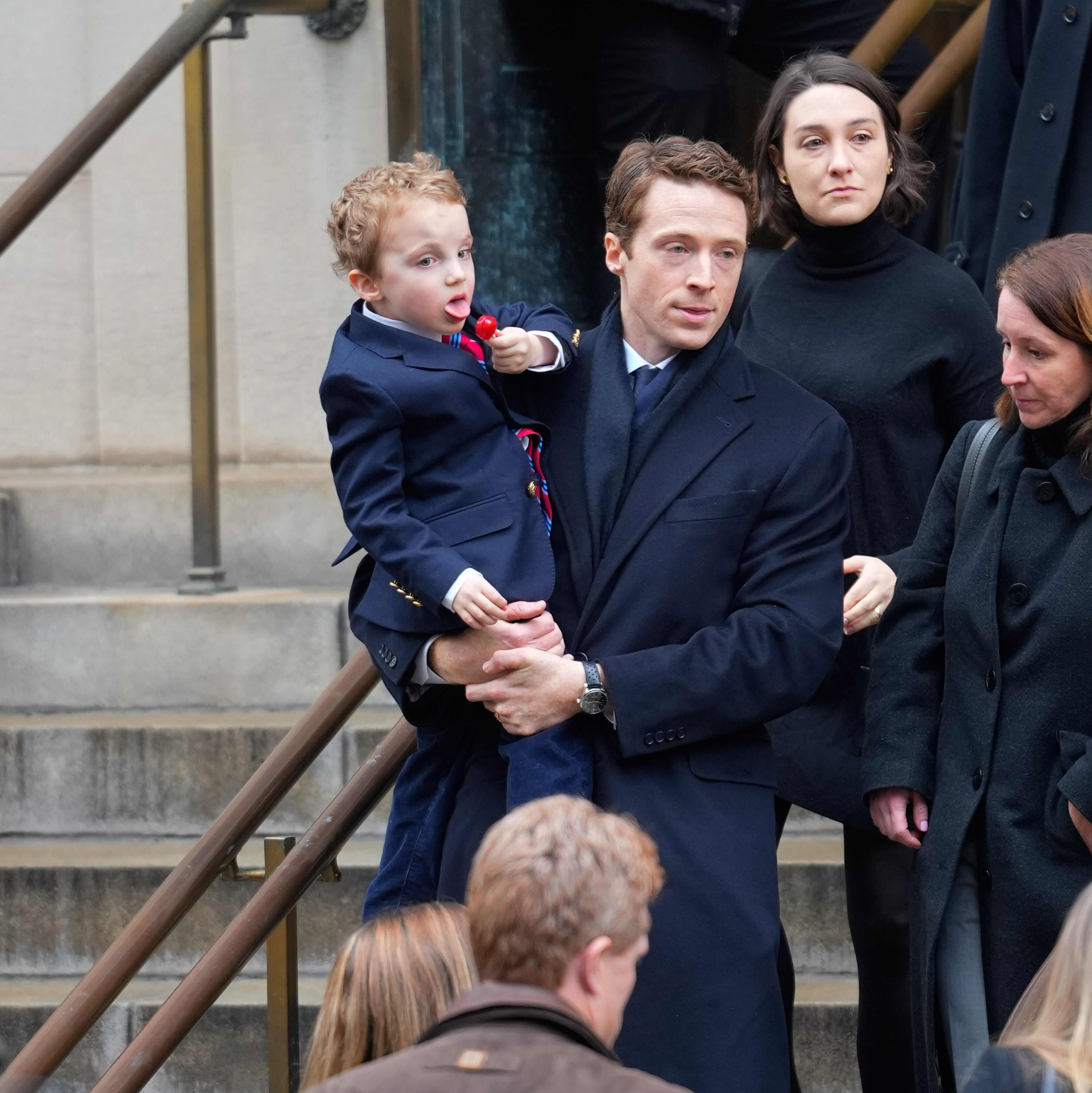 Grief was visible on the face of George Moran as he held one of his children. In this photo, he attended the funeral of his wife, Tatiana Schlossberg, at the Church of St. Ignatius Loyola on January 5, 2026, in New York City, New York. | Source: Getty Images