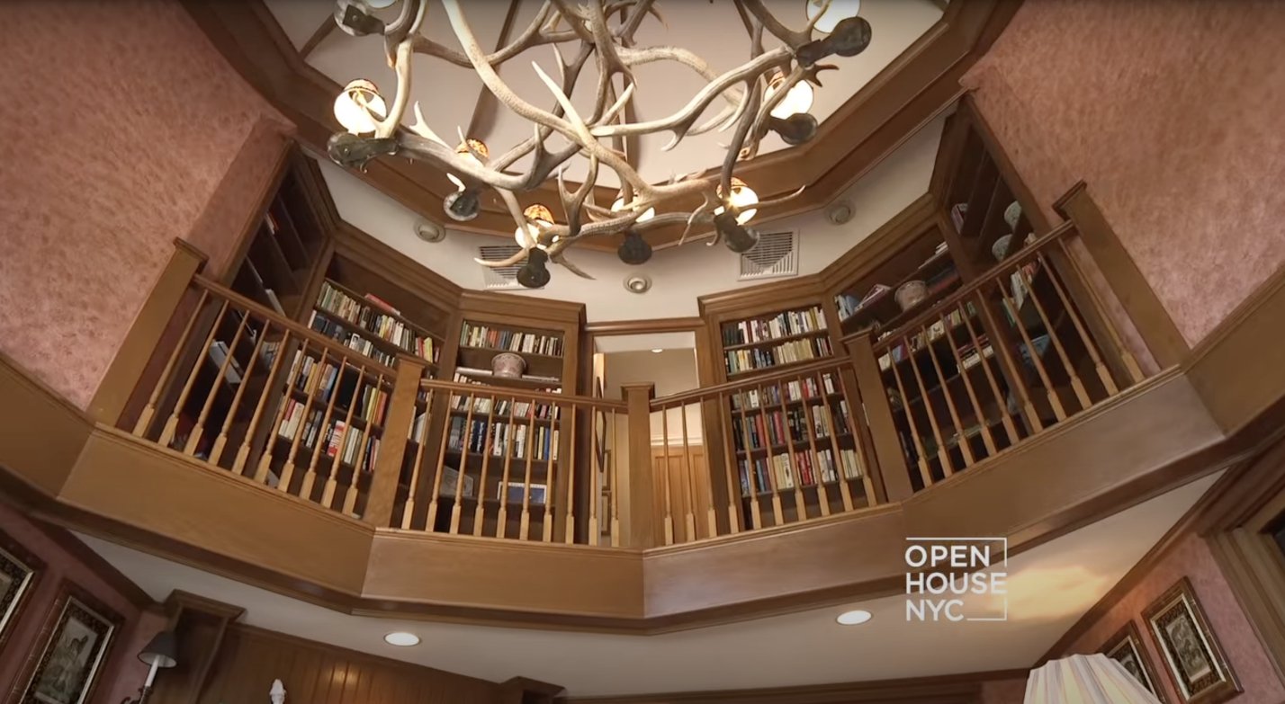 The library laced with an animal-like print floor design, cushion chairs and high bookshelves. | Source: youtube.com/Open House TV