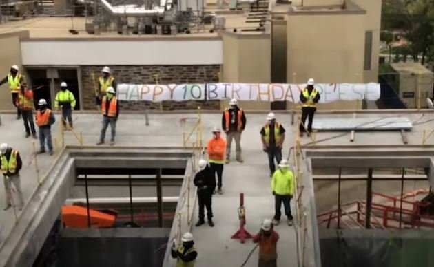 Trabajadores de una construcción con la pancarta de cumpleaños. | Foto: Youtube/Good Morning America