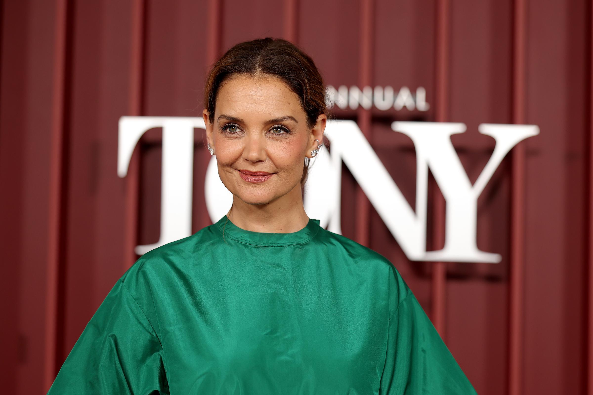 Katie Holmes steps onto the red carpet in a bold green satin top and blush pink beaded skirt, wearing her hair in a soft updo and keeping her makeup minimal as she prepares to present on Broadway's biggest night.