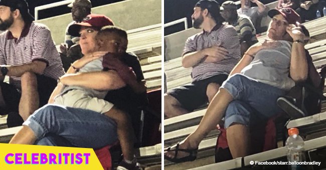 Heartwarming pic of little boy falling asleep in stranger's arms at football game goes viral