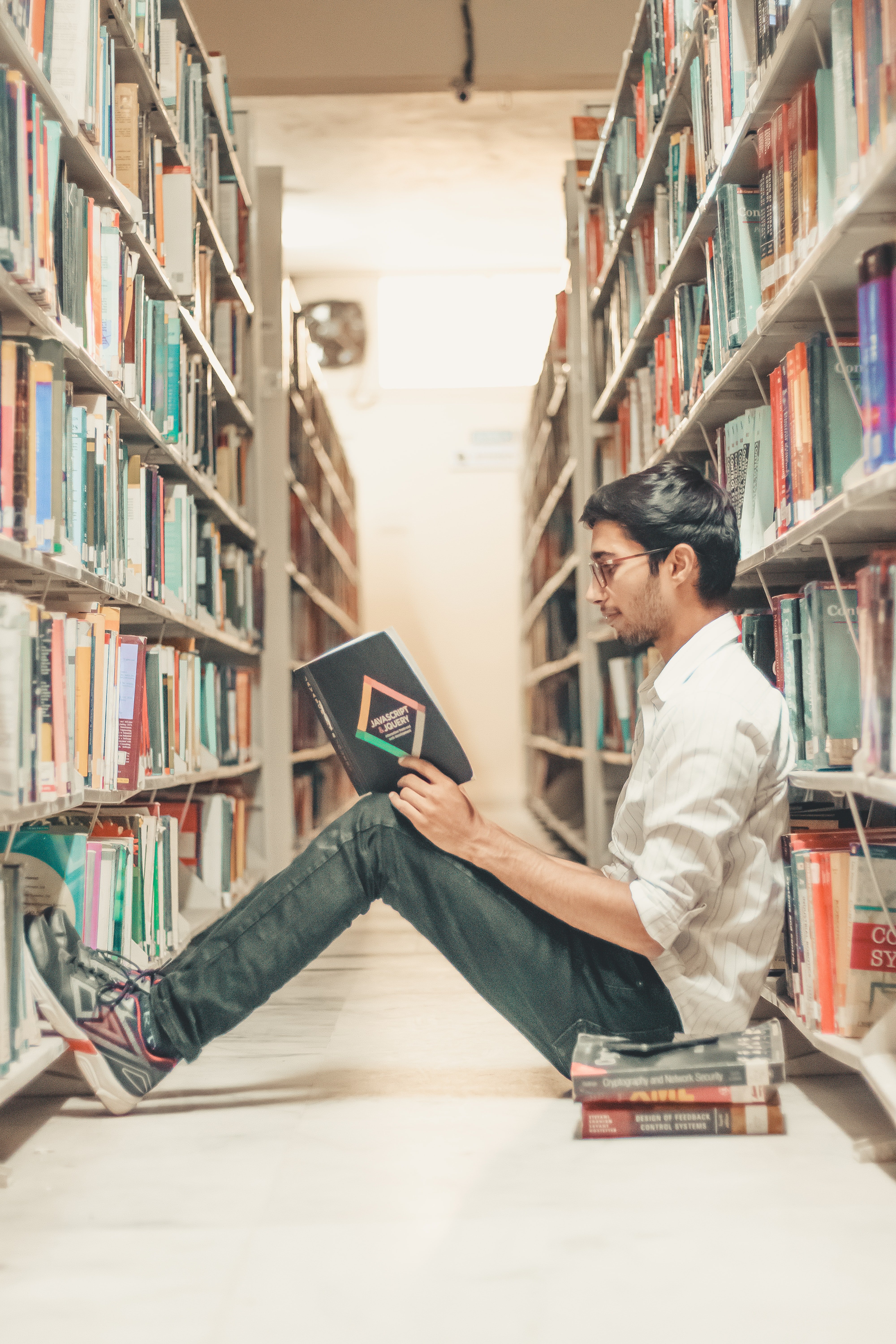 Un joven lee un libro en la biblioteca. | Foto: Unsplash