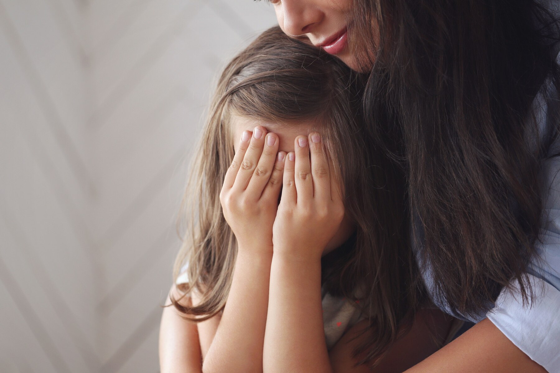 A woman hugging her crying child | Source: Freepik