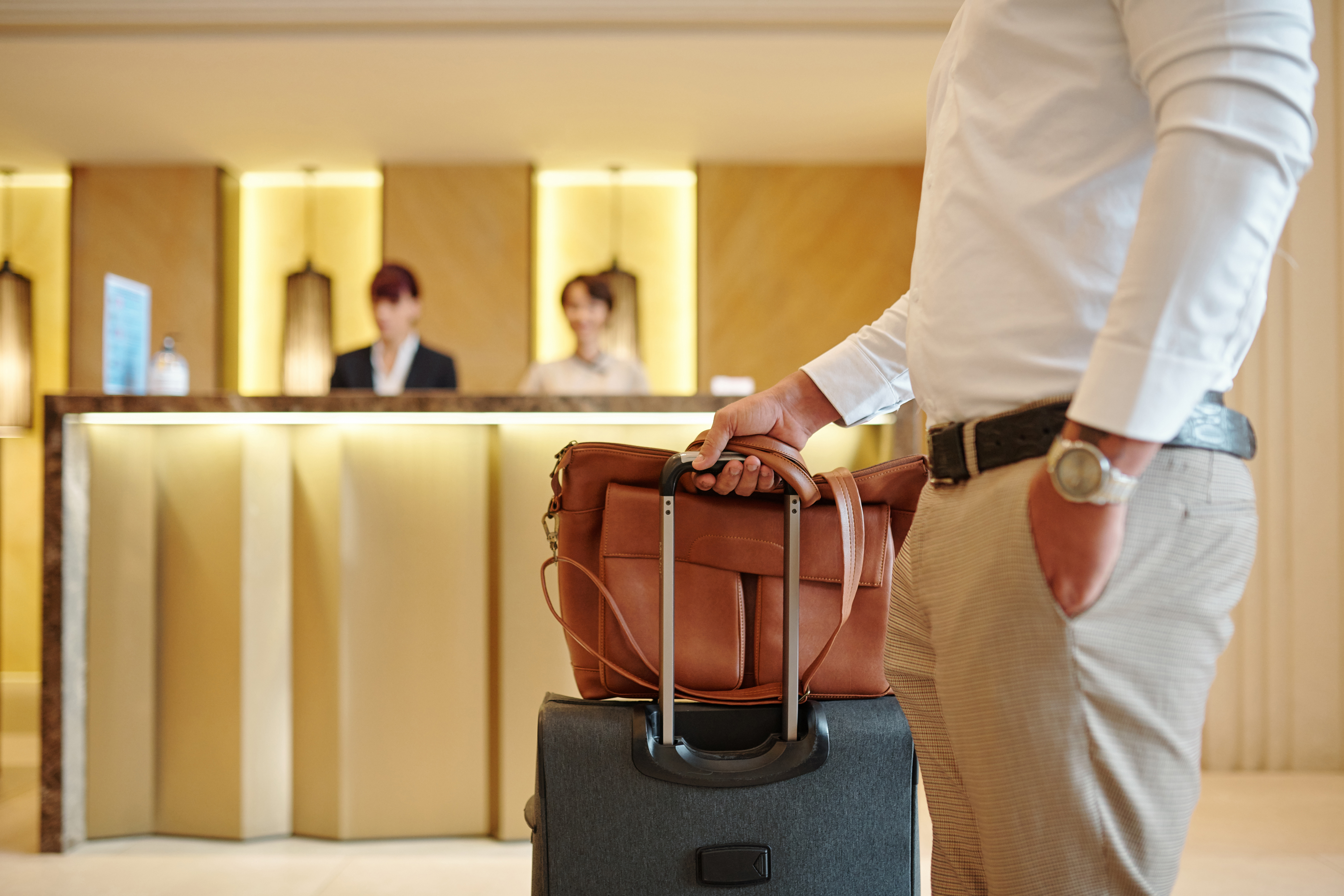 A man standing with his luggage after checking into a hotel | Source: Shutterstock