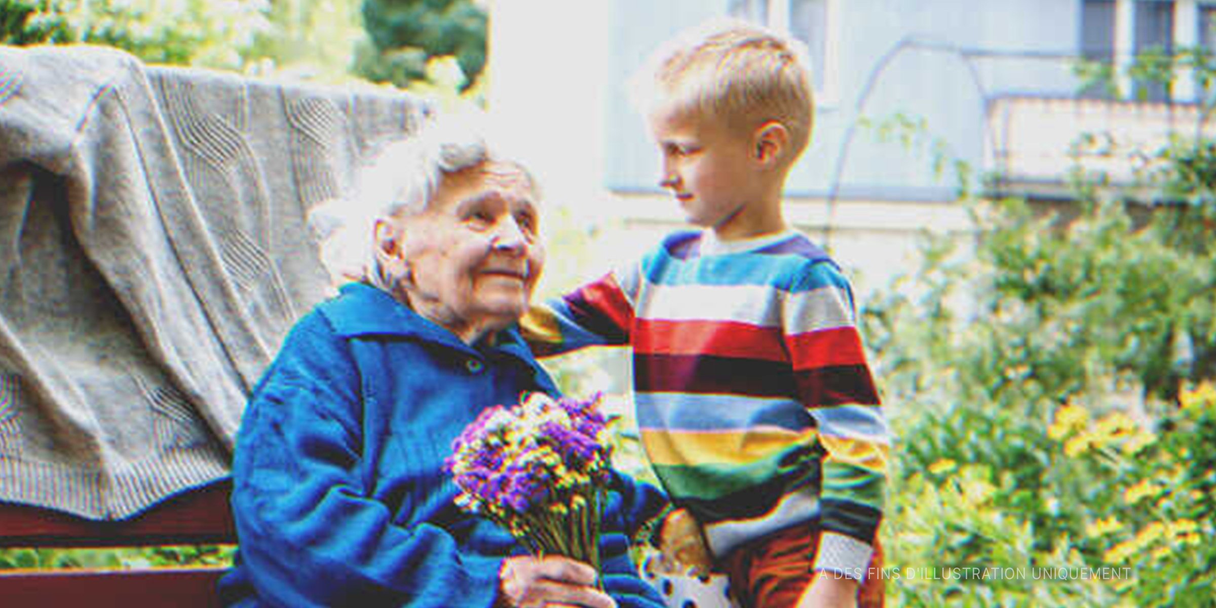 Une grand-mère qui tient des fleurs et un petit garçon | Source : Getty Images