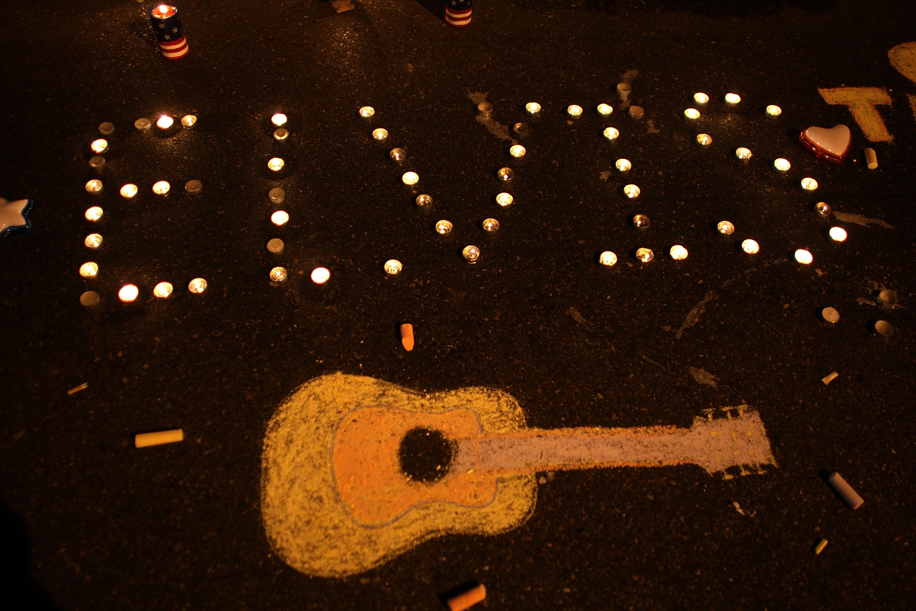 An arrangement of candles spelling out "Elvis" beside a chalk depiction of a guitar during the 30th anniversary of Elvis Presley's death in Graceland on August 15, 2007 | Source: Getty Images