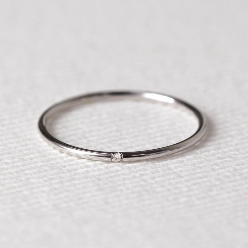 Alianza de boda minimalista de JSVConcepts Joyería fina en oro blanco con un diamante. | Fuente: Etsy.com
