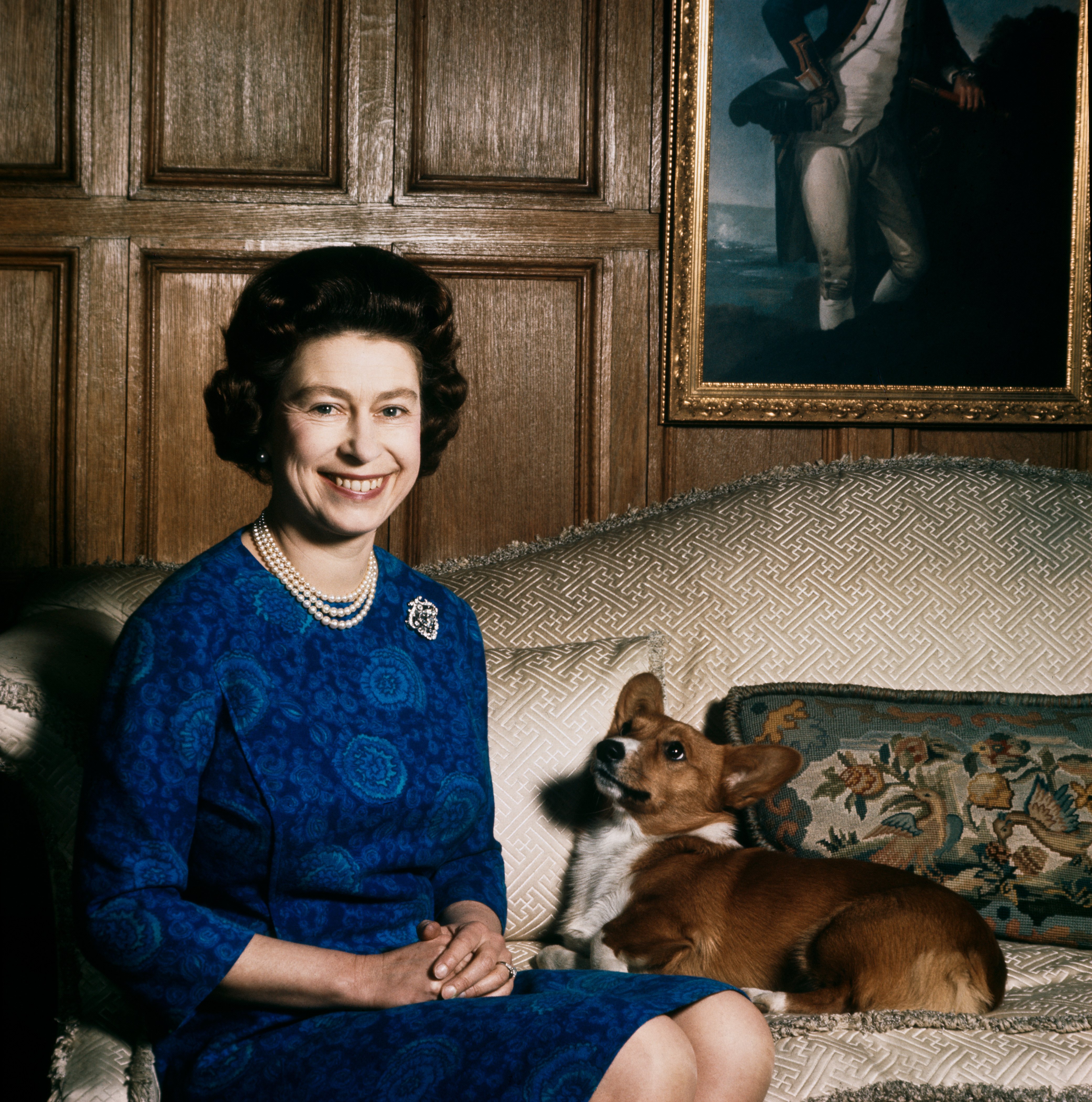 Queen Elizabeth II smiles beside her corgi in 1970 at Sandringham House in Norfolk, England. | Source: Getty Images
