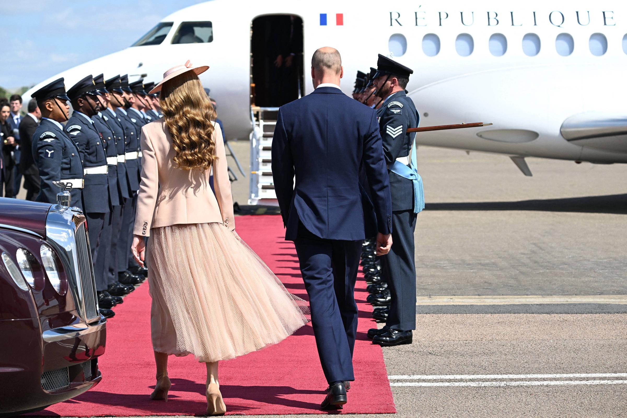 Princess Catherine and Prince William prepare to welcome French President Emmanuel Macron and First Lady Brigitte Macron. The Princess' softly curled locks are on full display, adding to her elegant appearance.