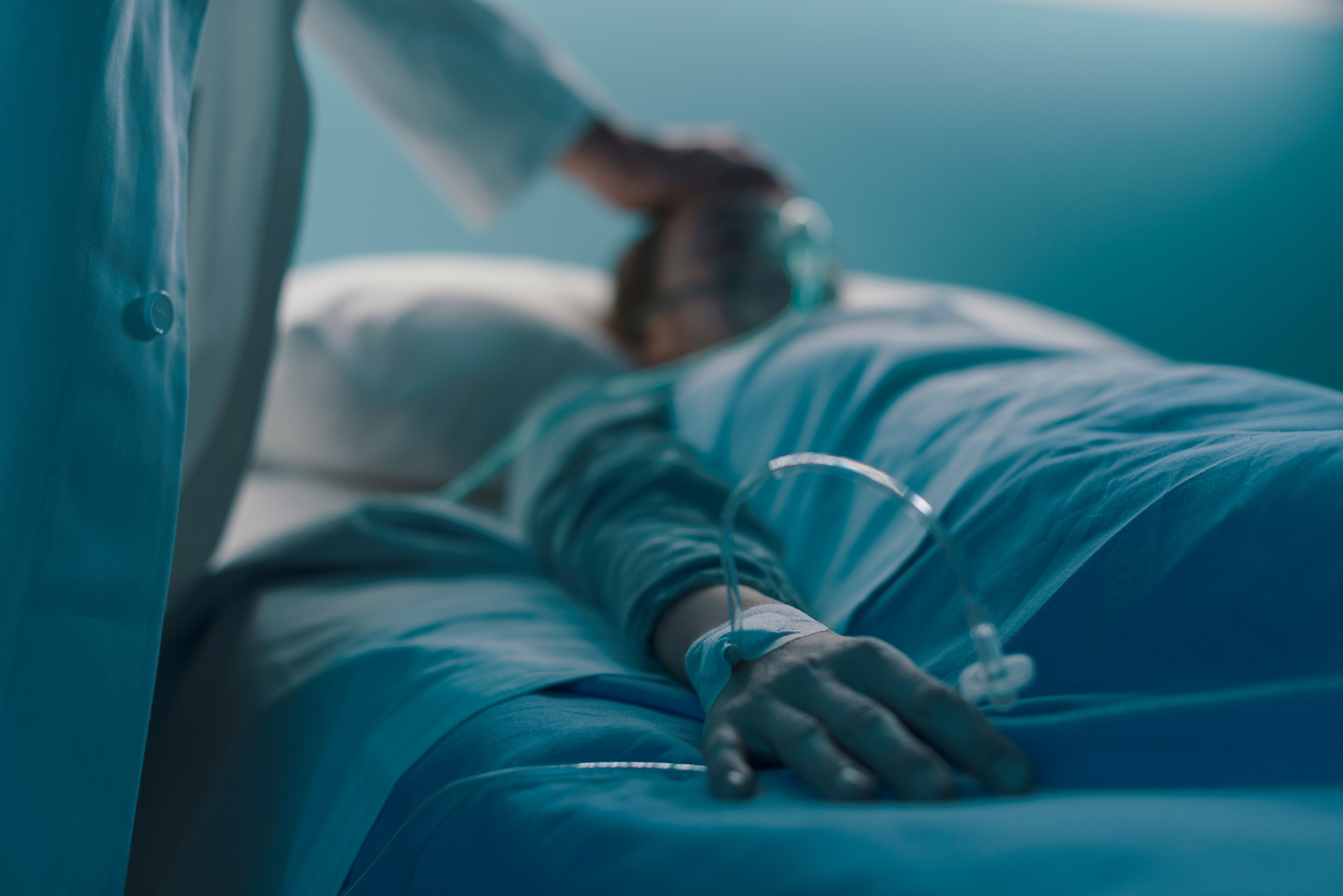 Patient lying in a hospital bed while a doctor is doing a check-up | Photo: Shutterstock/Stokkete