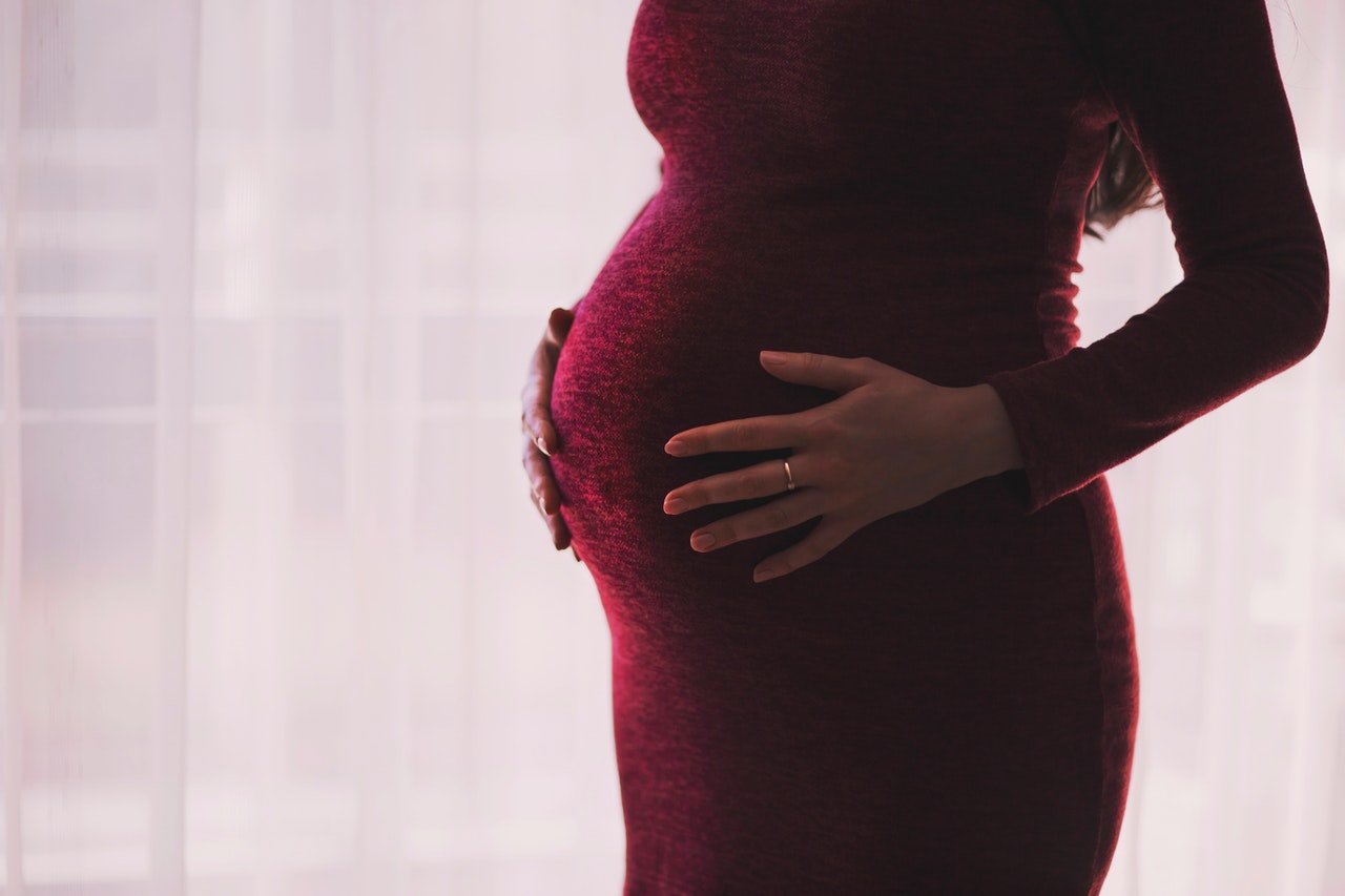 Pregnant woman holding her baby bump | Photo: Pexels