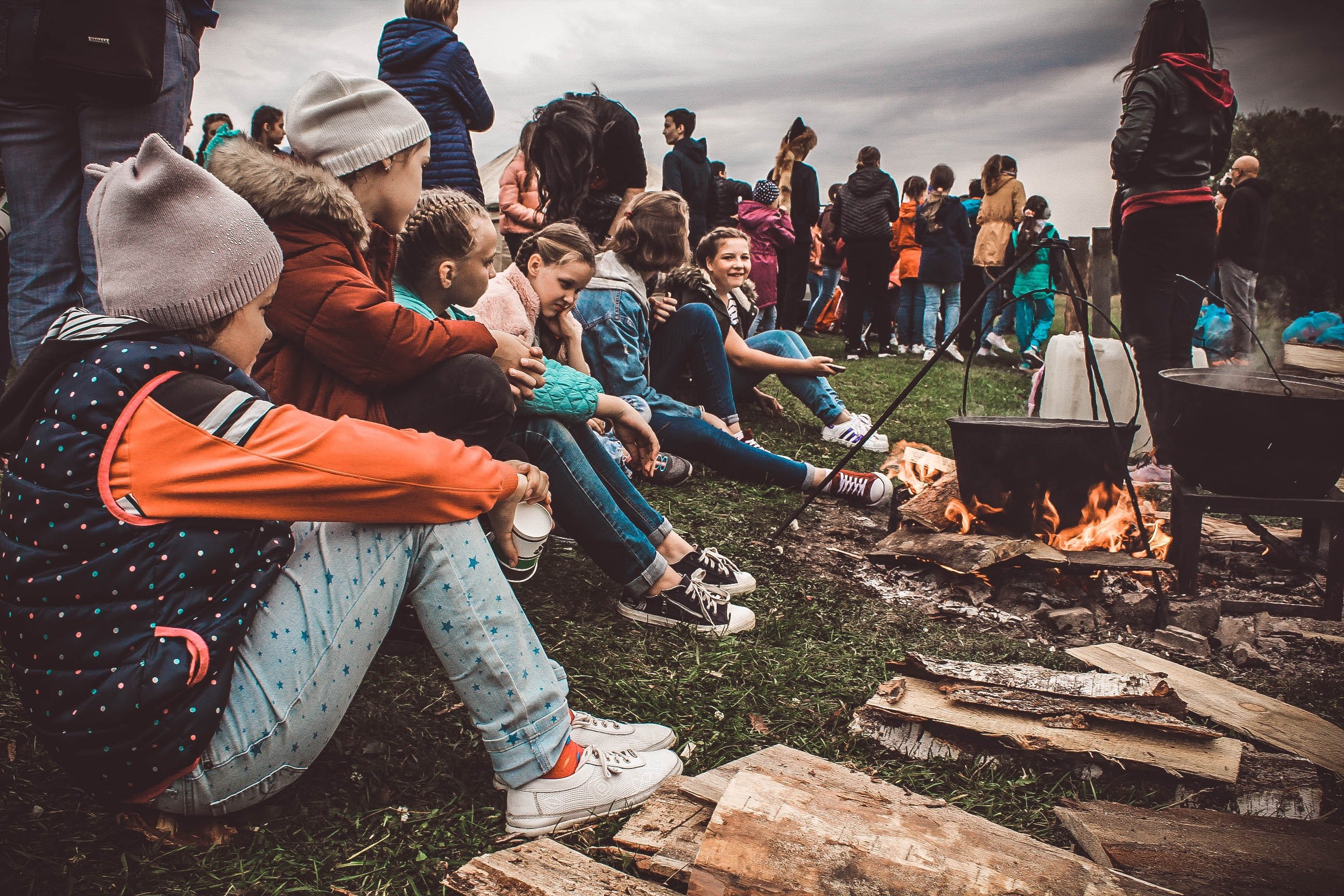 Group of kids sitting next to a fire pit | Source: Unsplash