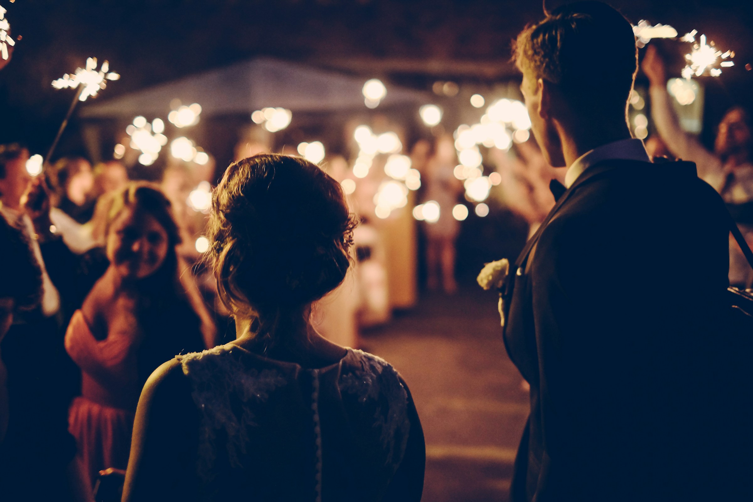 Rear view of a newlywed couple at their wedding after-party | Source: Unsplash