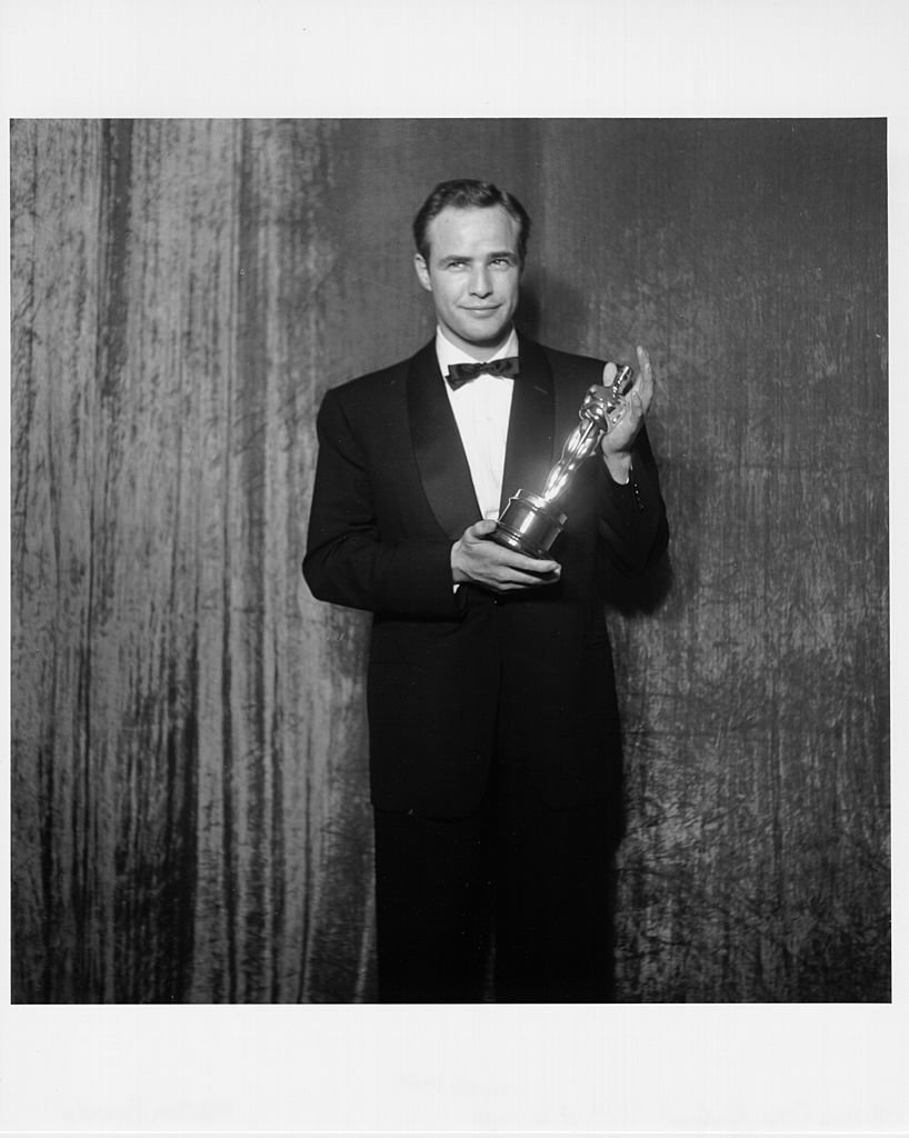 Marlon Brando pose dans les coulisses de la 27e cérémonie des Oscars, tenant un Oscar pour sa performance dans le film "On The Waterfront", le 30 mars 1955. | Photo : Getty Images