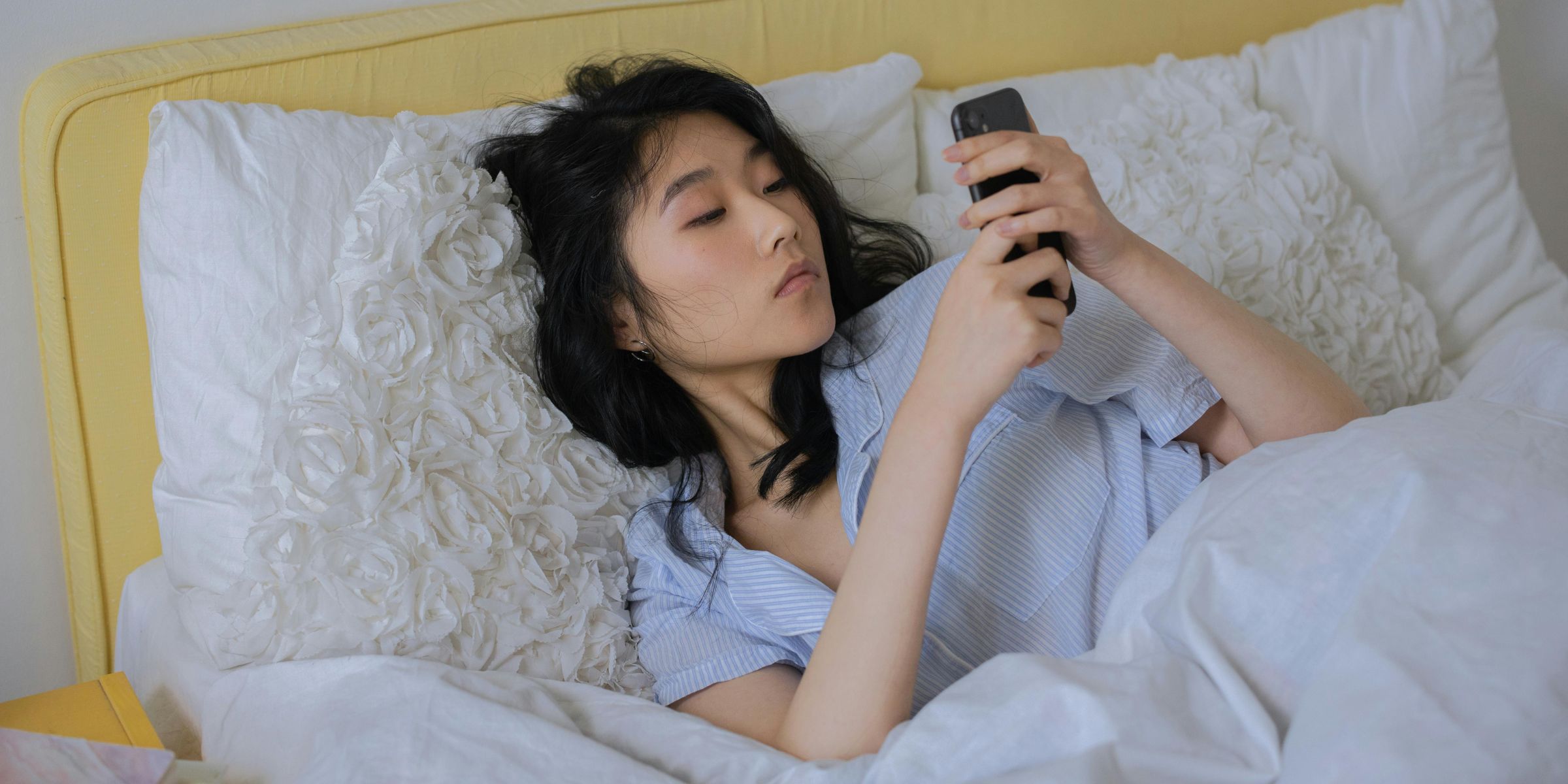 A woman on her phone in bed | Source: Pexels