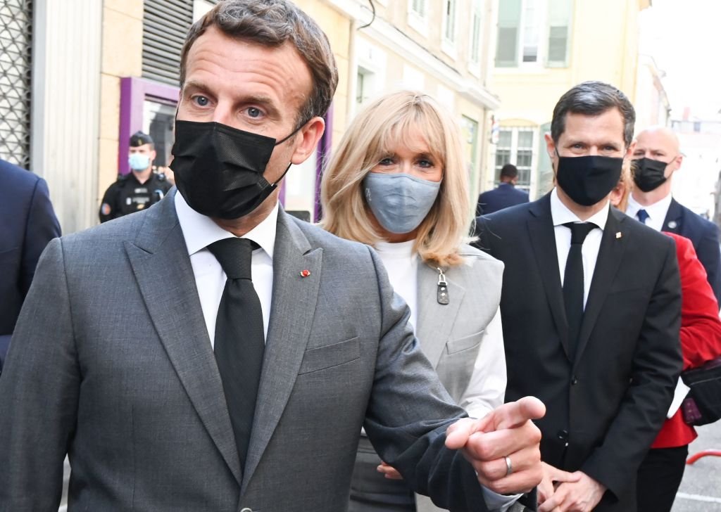 Le président français Emmanuel Macron (à gauche), son épouse Brigitte Macron (au centre) et le maire de Valence Nicolas Daragon (à droite) marchent dans une rue de Valence le 8 juin 2021 lors d'une visite dans le département de la Drôme. | Photo : Getty Images