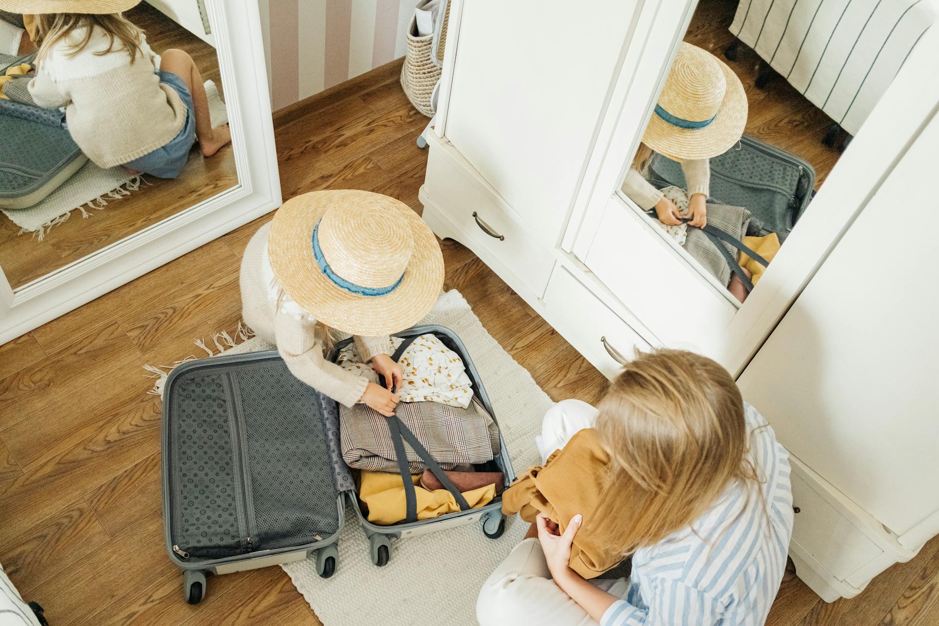 A woman and child packing a suitcase | Source: Pexels