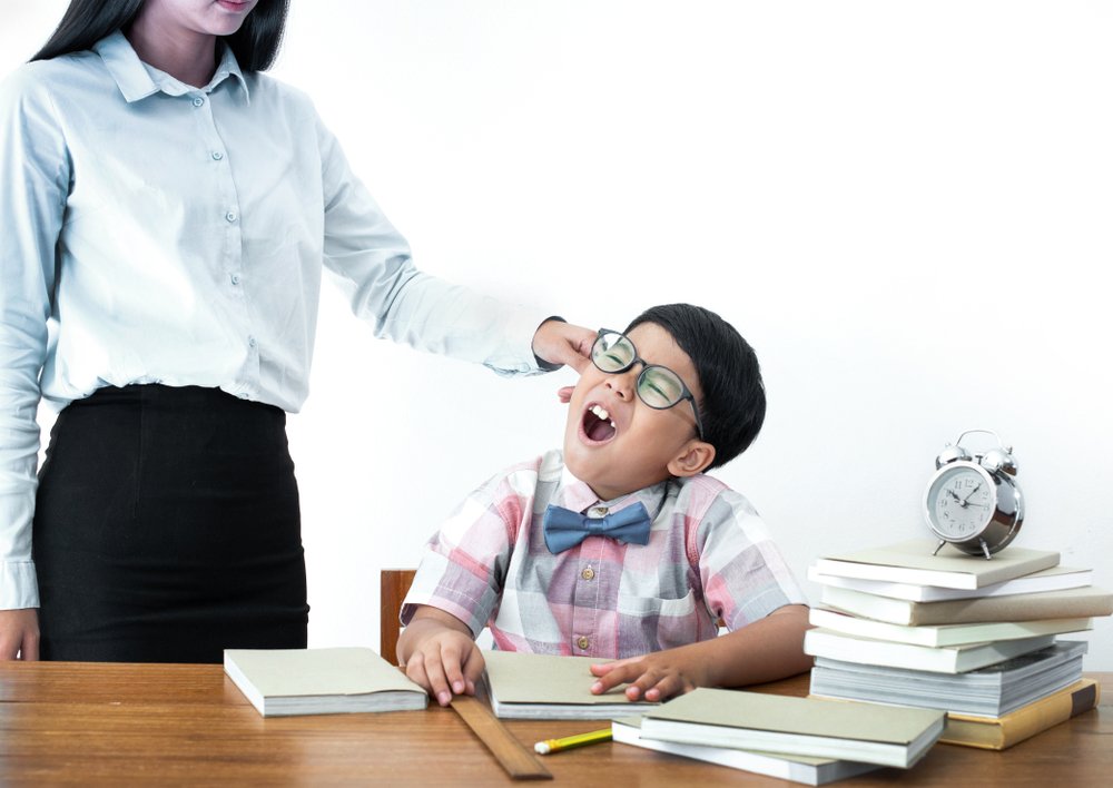 Profesora jalando la oreja de un alumno. Fuente: Shutterstock