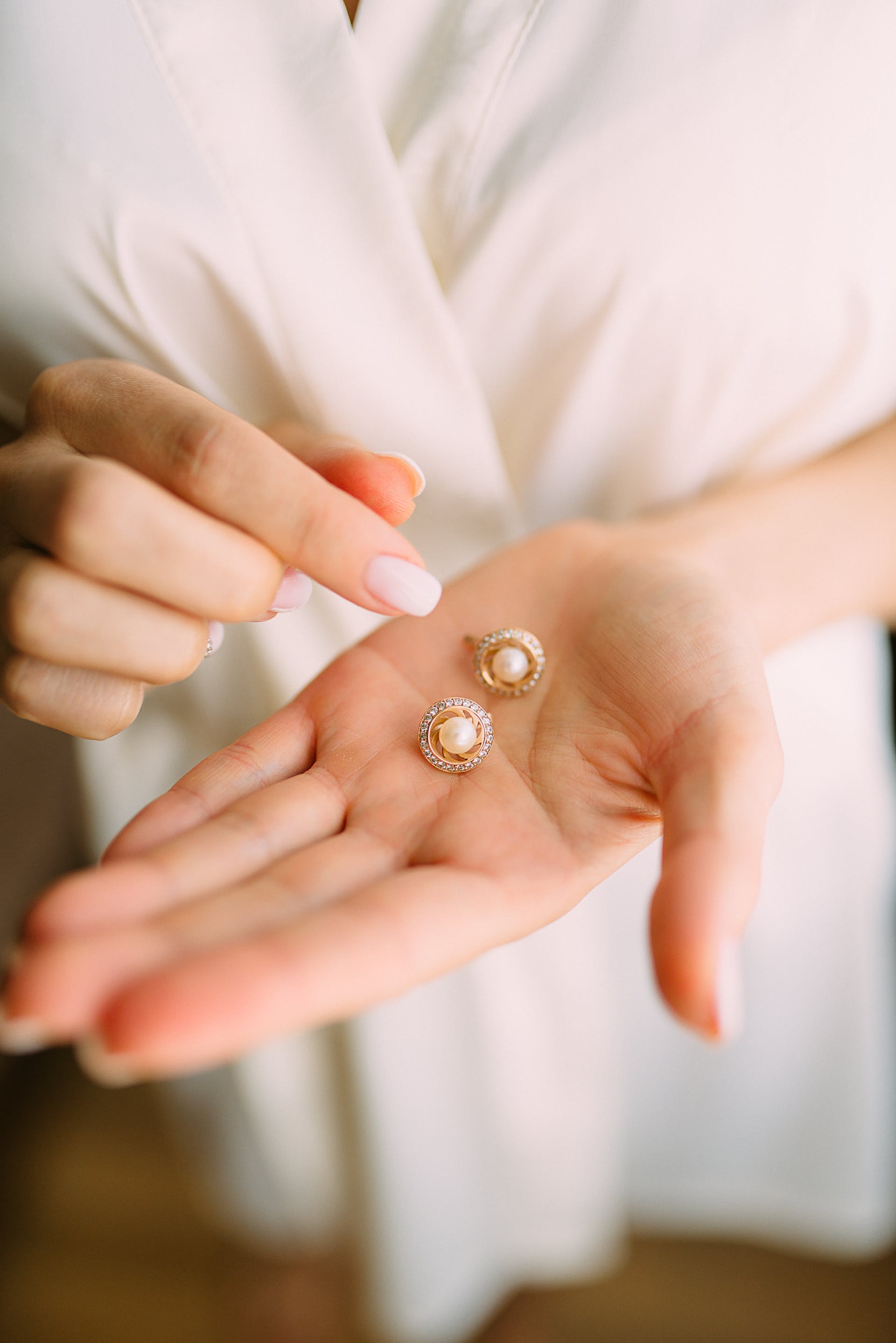 A woman holding earrings | Source: Pexels