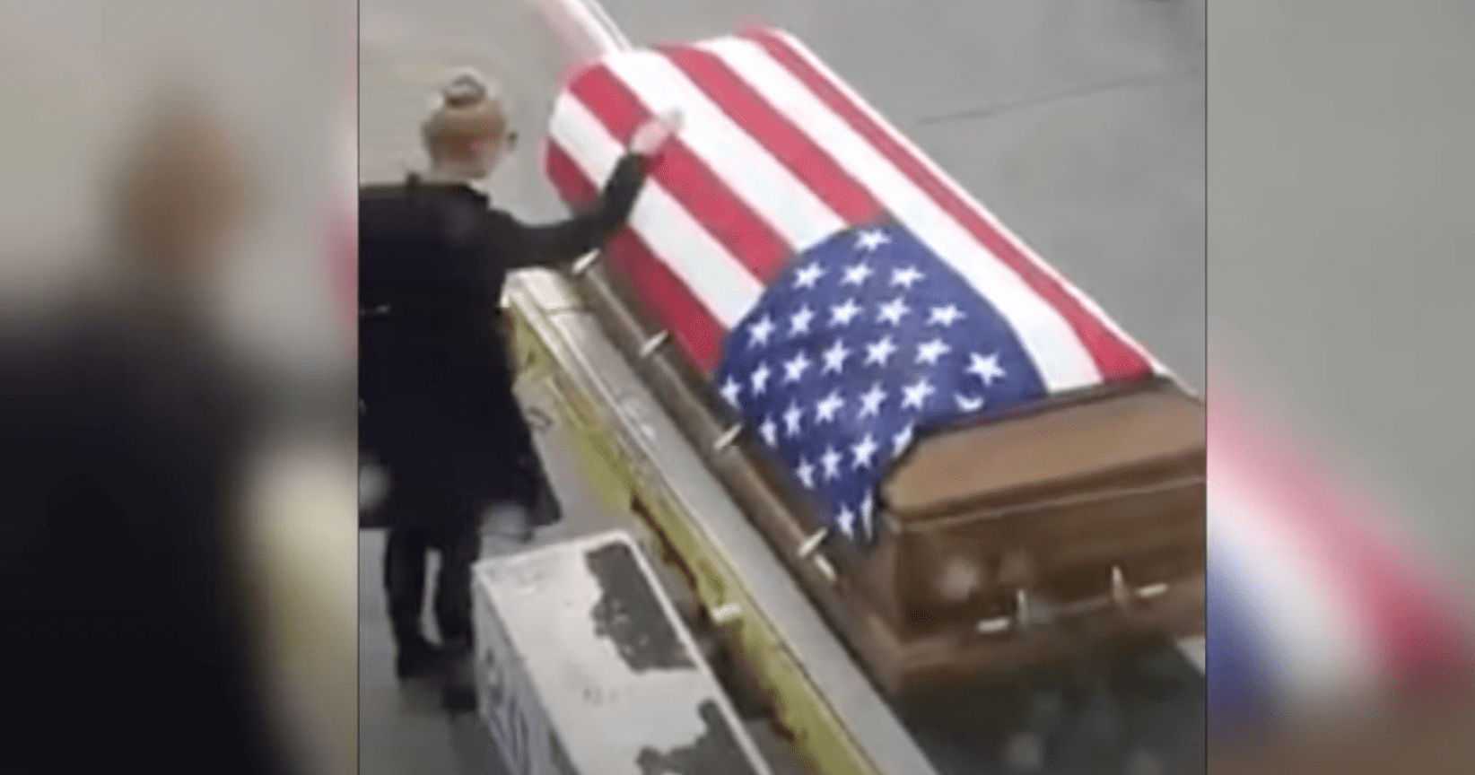 Tara Thomas places her hand on the flag-draped coffin. | Source: YouTube.com/Inside Edition