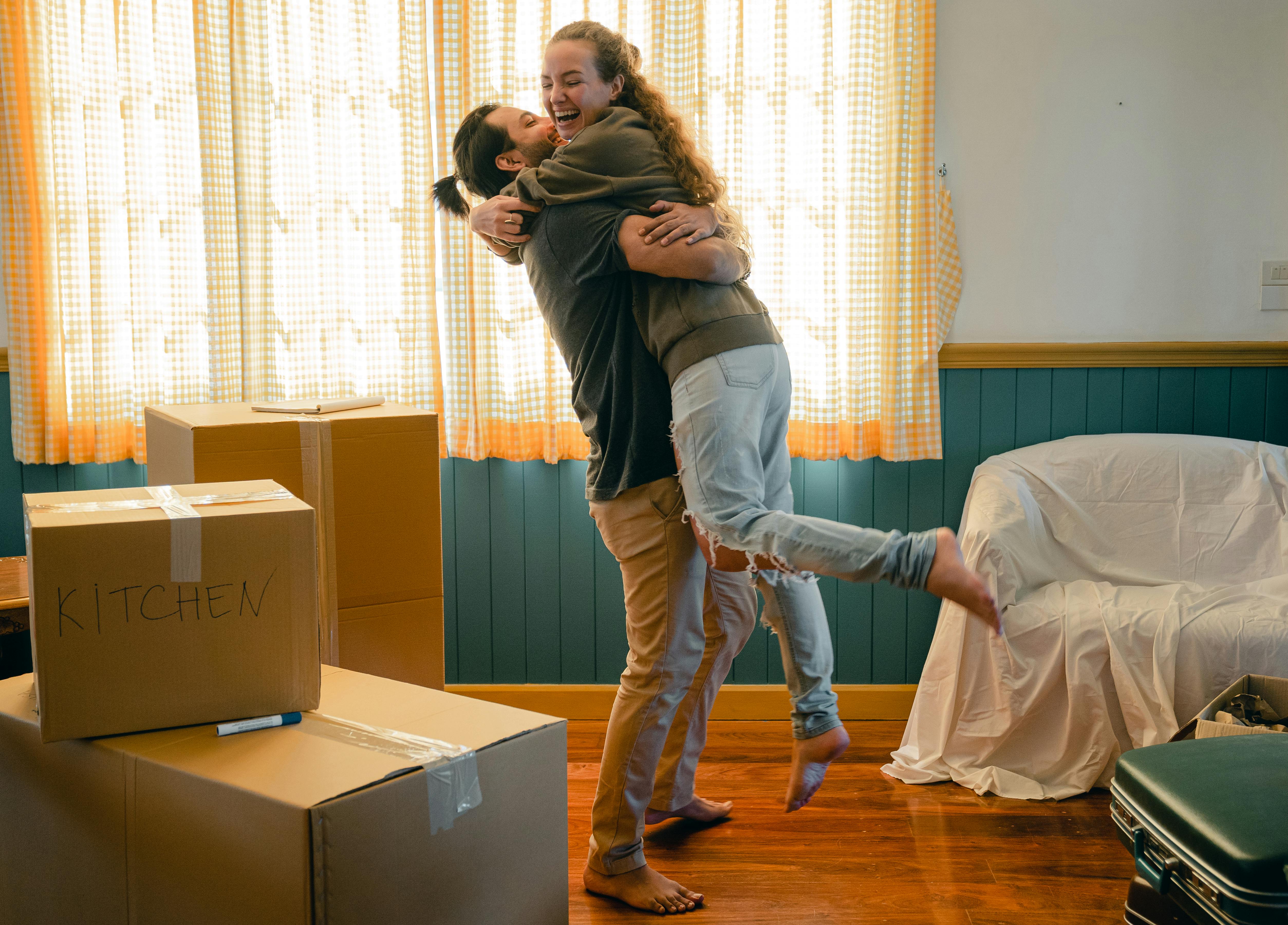 Cheerful couple hugs after moving | Source: Pexels