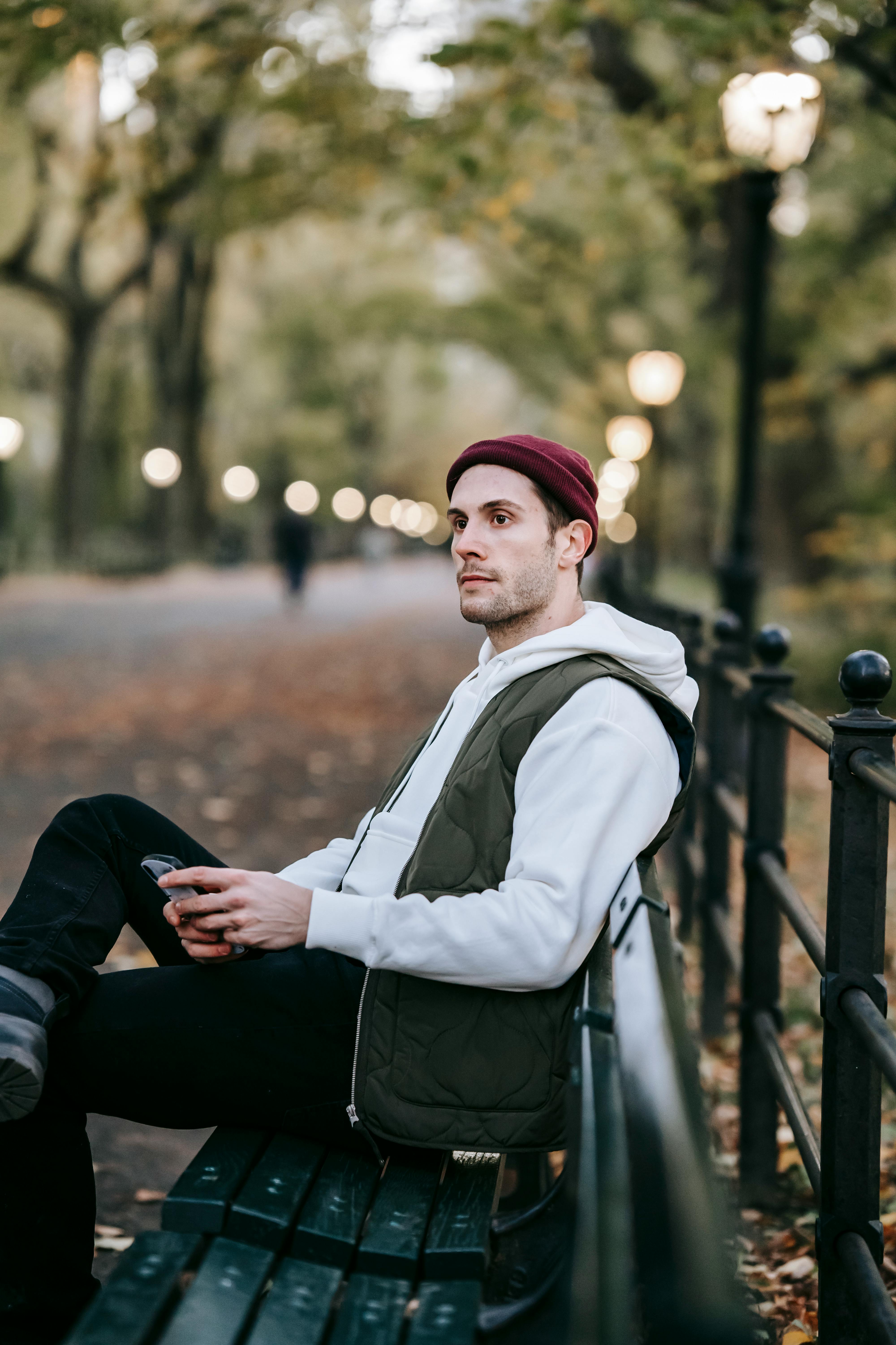 A man sitting on a bench contemplating something he saw on his phone | Source: Pexels