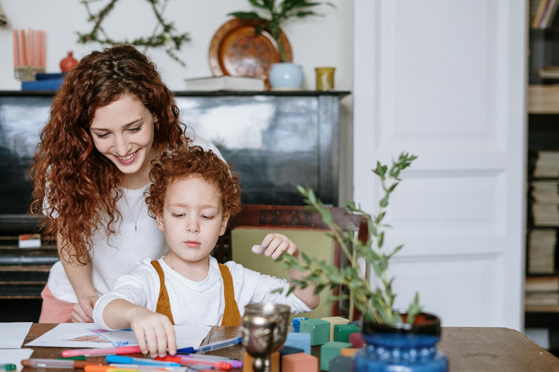 A woman watching her child draw | Source: Pexels