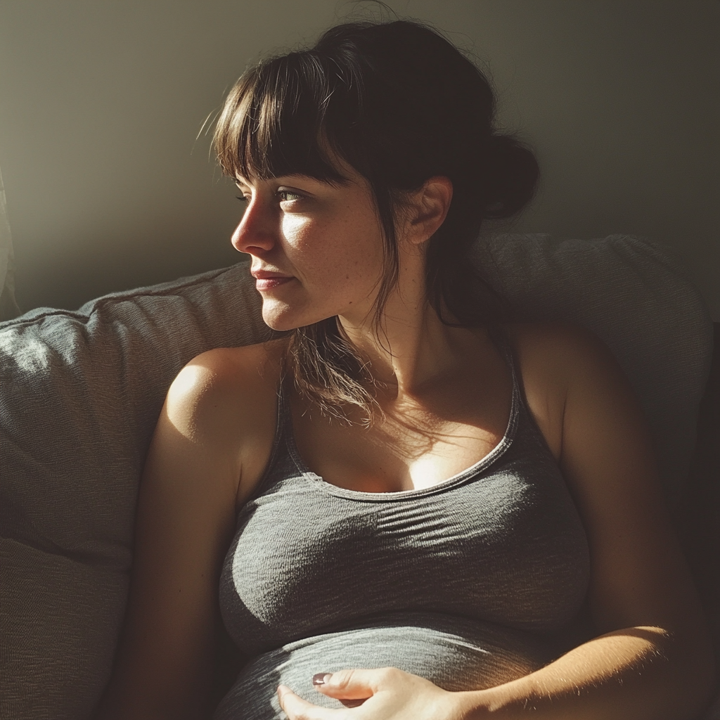 A pregnant woman sitting on a couch | Source: Midjourney