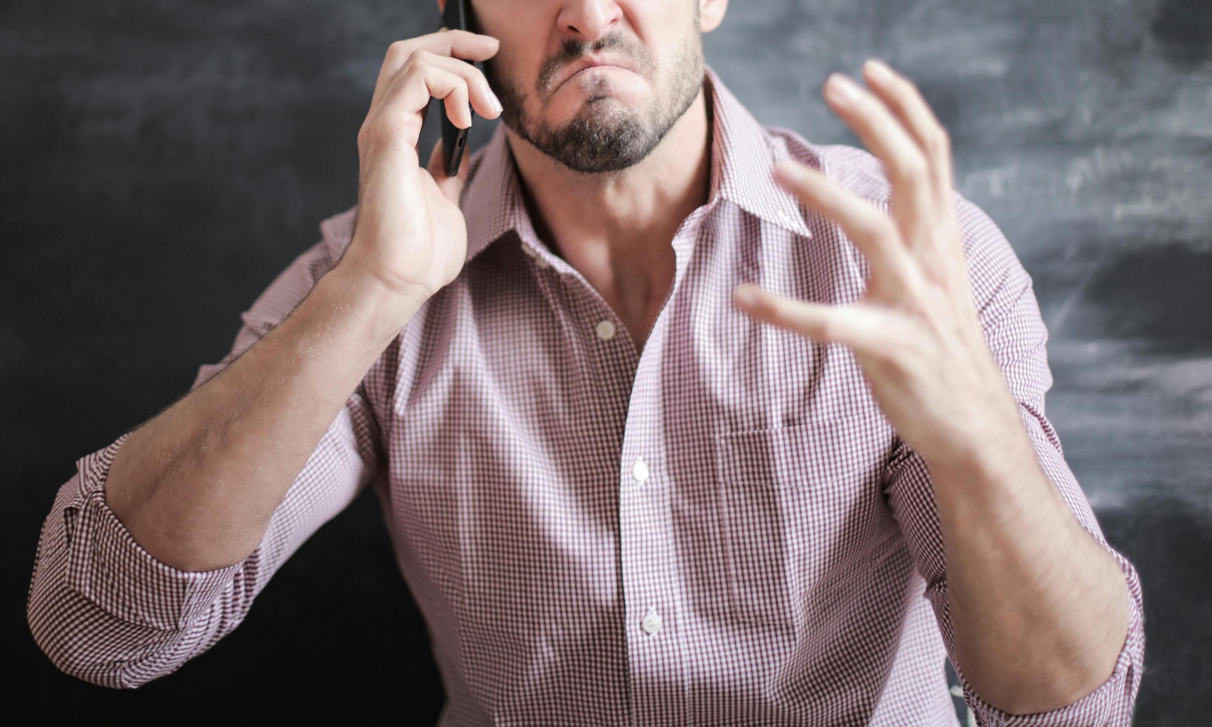 A man reacts angrily while talking on a cell phone | Source: Pexels