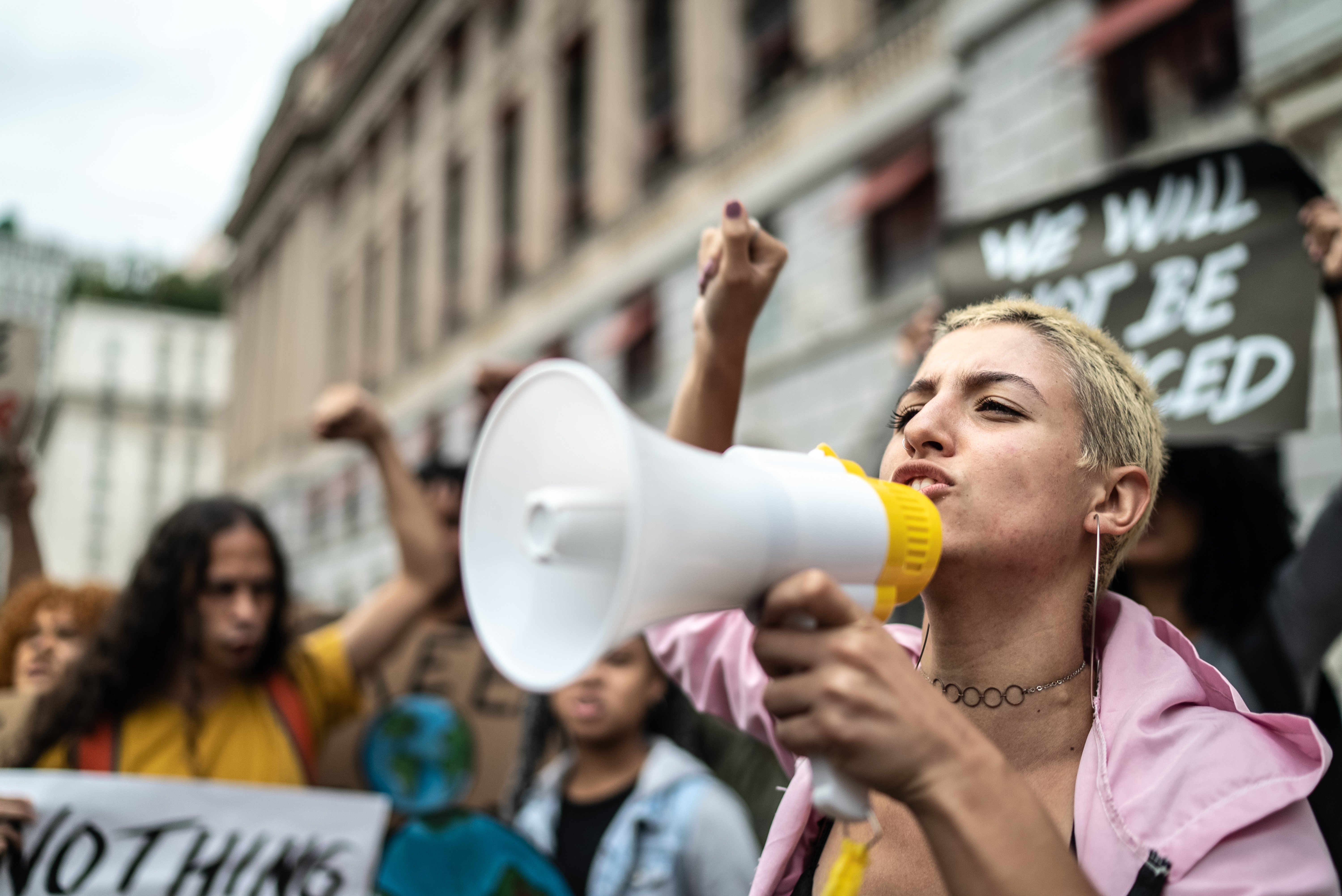 A young woman leading a demonstration using a megaphone | Source: Getty Images