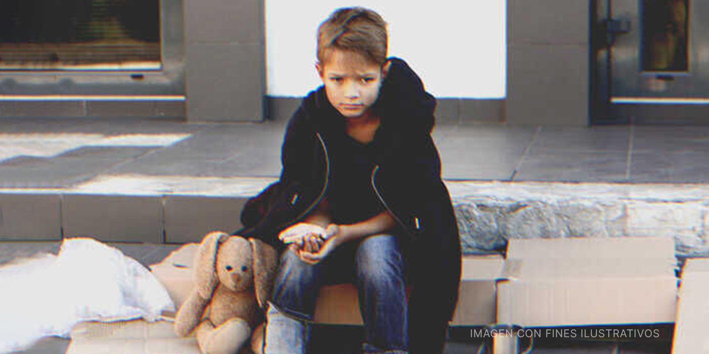 Niño triste sentado en la calle | Foto: Shutterstock