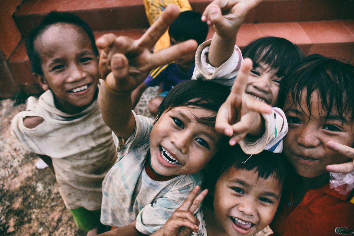 Un grupo de niños felices miran hacia arriba. | Foto: Unsplash