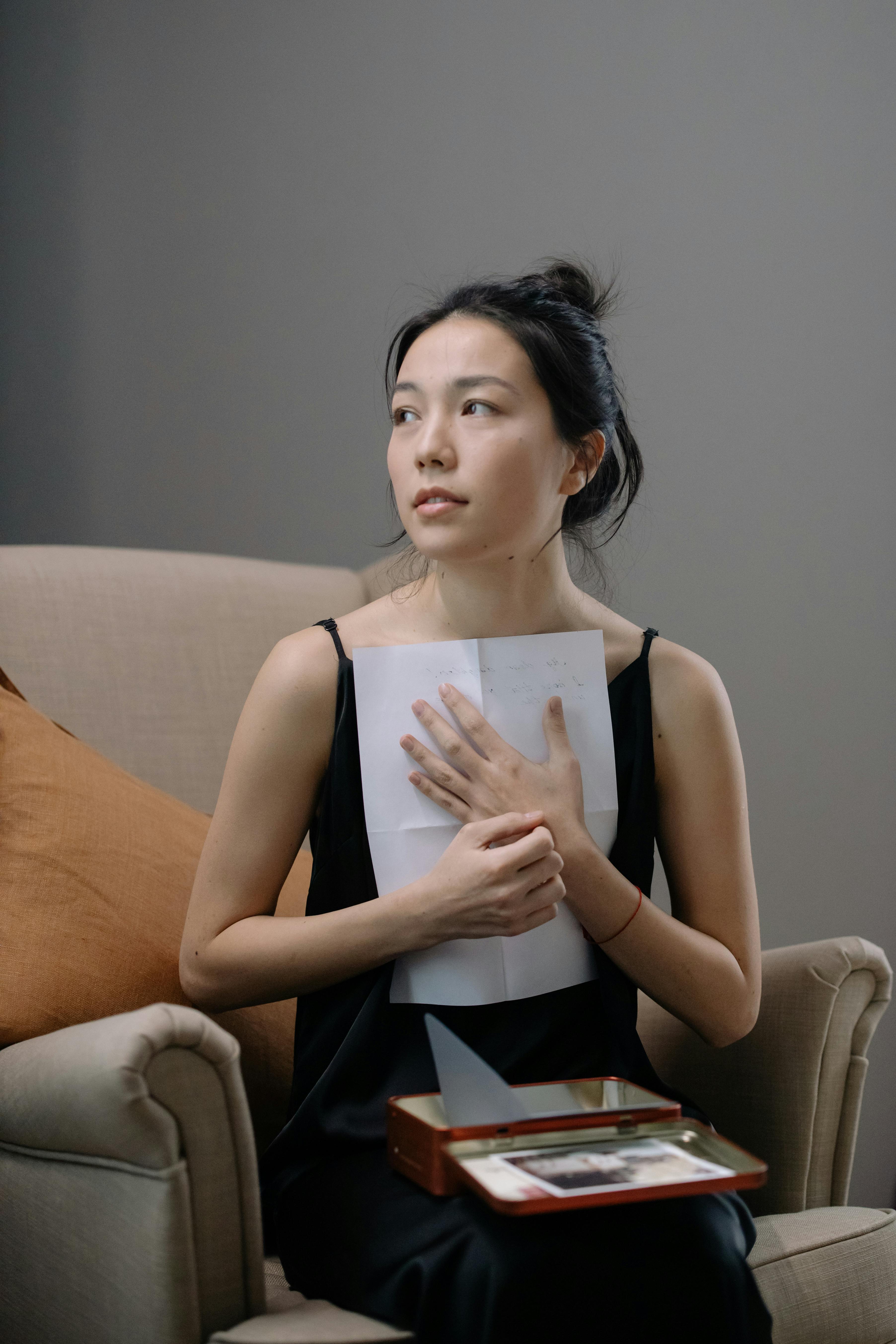 A woman holds a letter to her chest | Source: Pexels